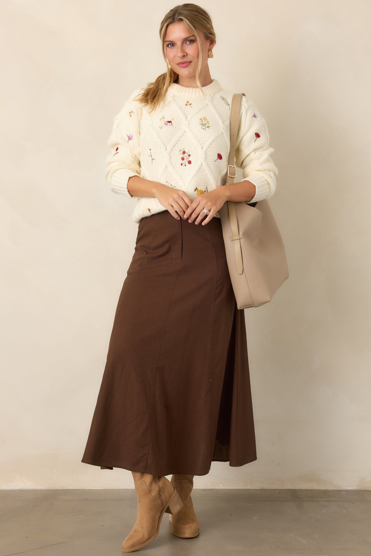 Ivory textured knit top featuring miniature floral sprigs, berries, fruit, and garden motifs scattered across the front and long sleeves.