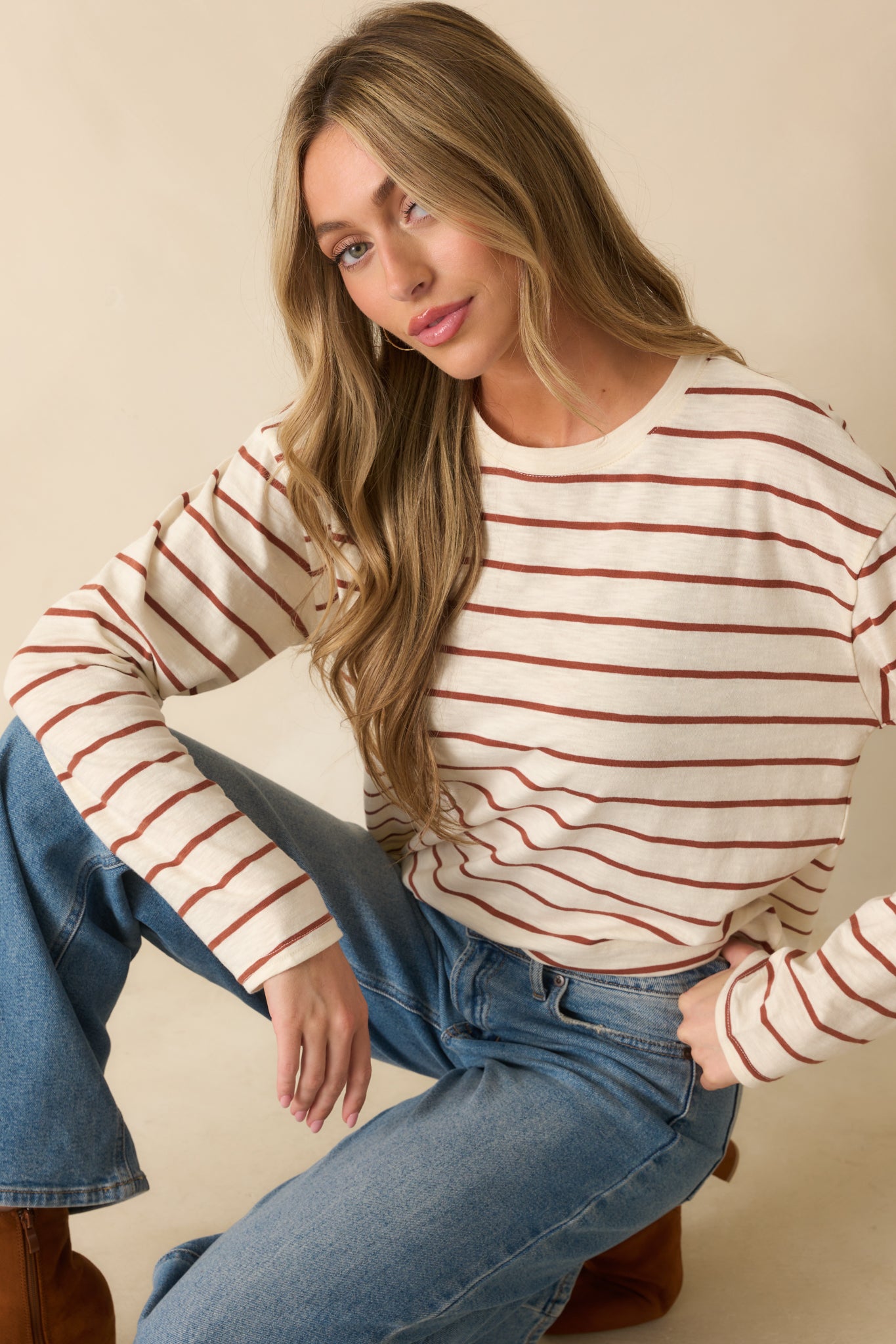 Cropped front view emphasizing the crew neckline, long sleeves, and stripe pattern of the ivory and cinnamon top.