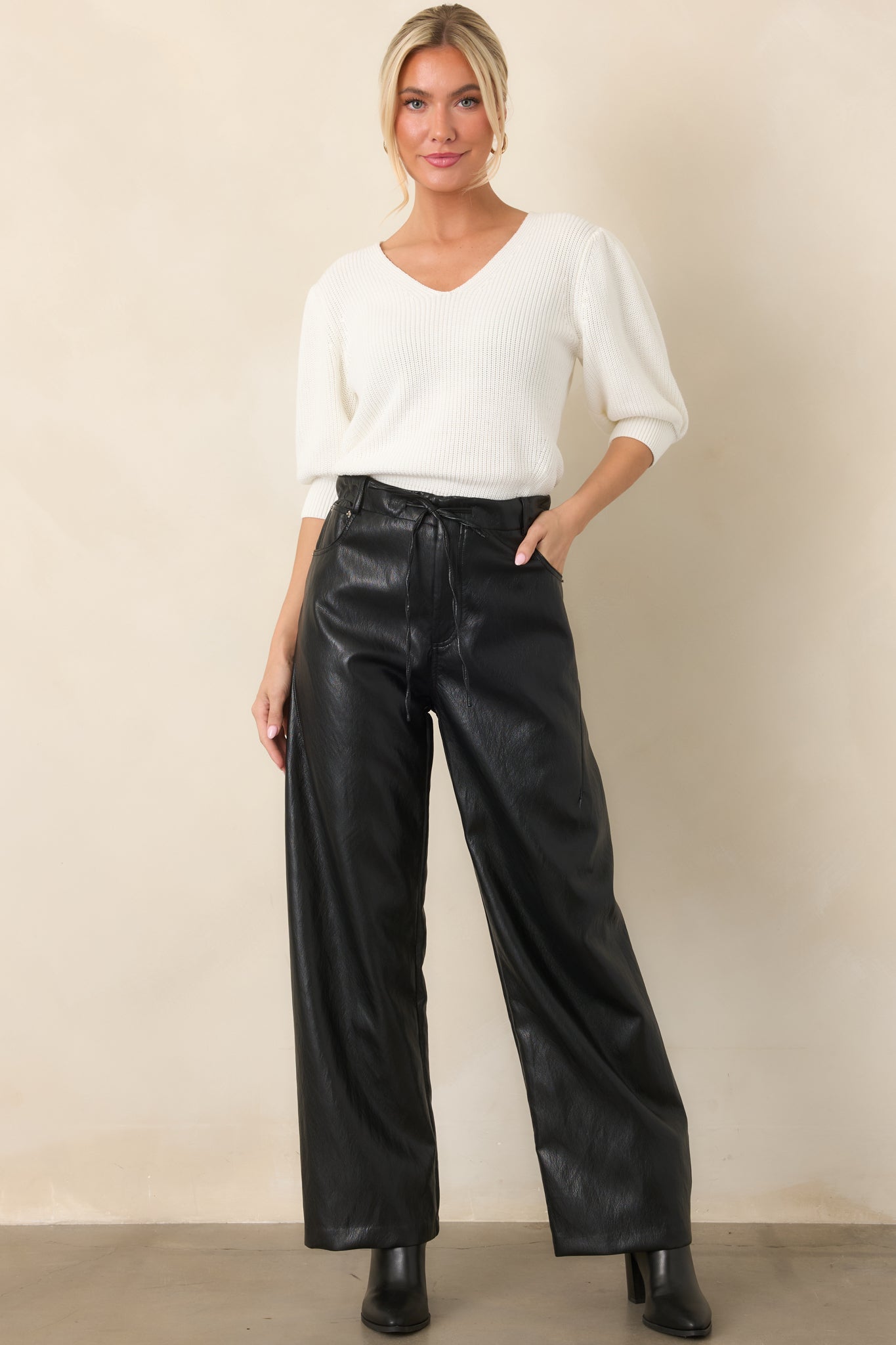 Soft ivory top showcasing elbow-length puff sleeves, ribbed cuffs, a V-neckline, and structured silhouette.
