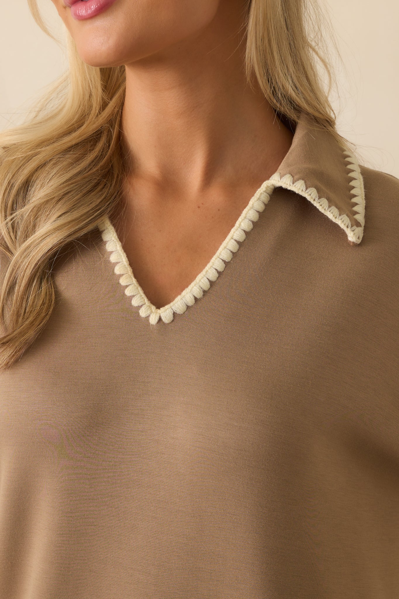 Ivory whipstitch trim detailing on the neckline and collar of the tan knit maxi dress.