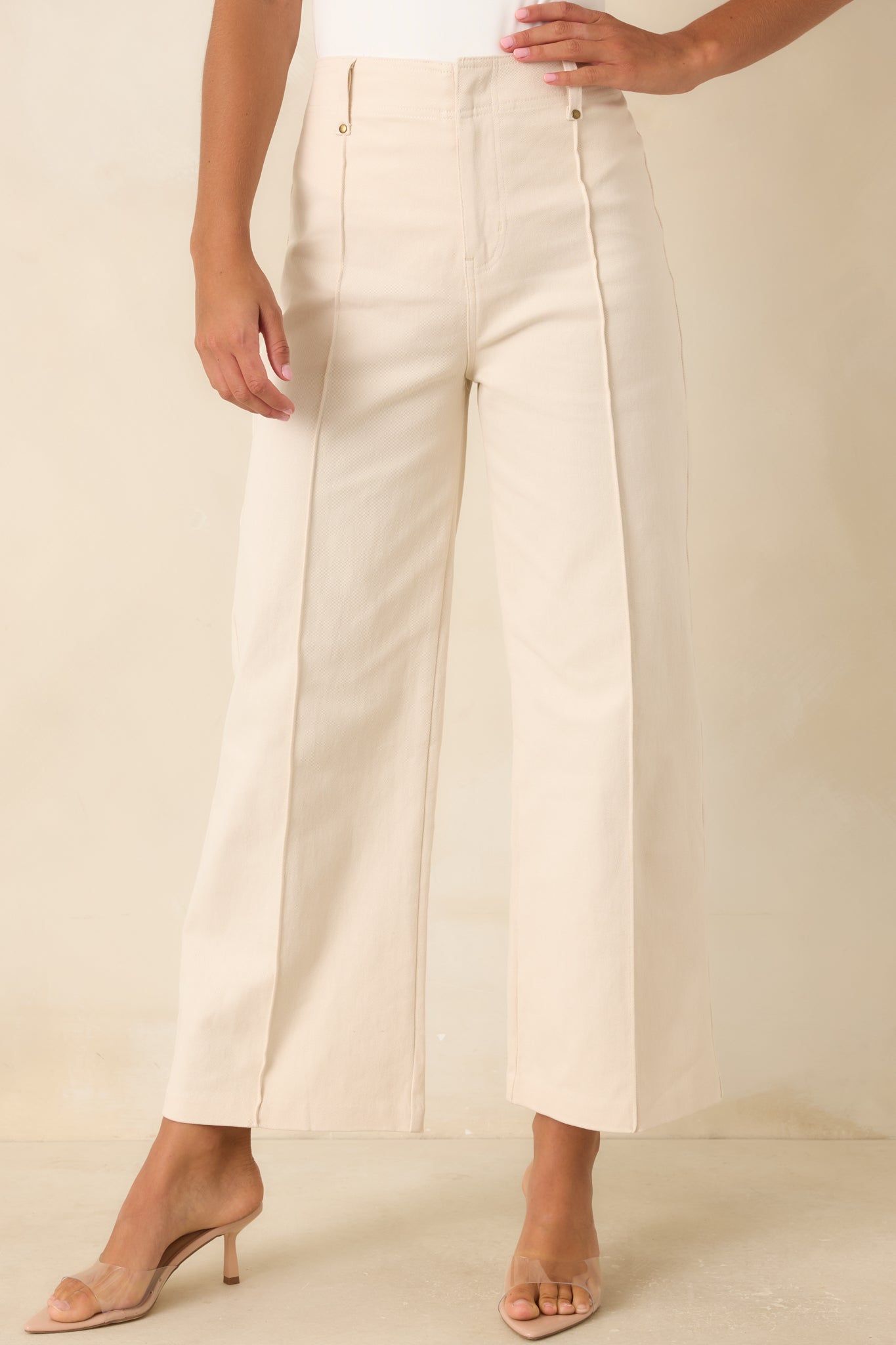 Close front view of the ivory wide leg pants featuring functional belt loops and a structured high-rise fit.
