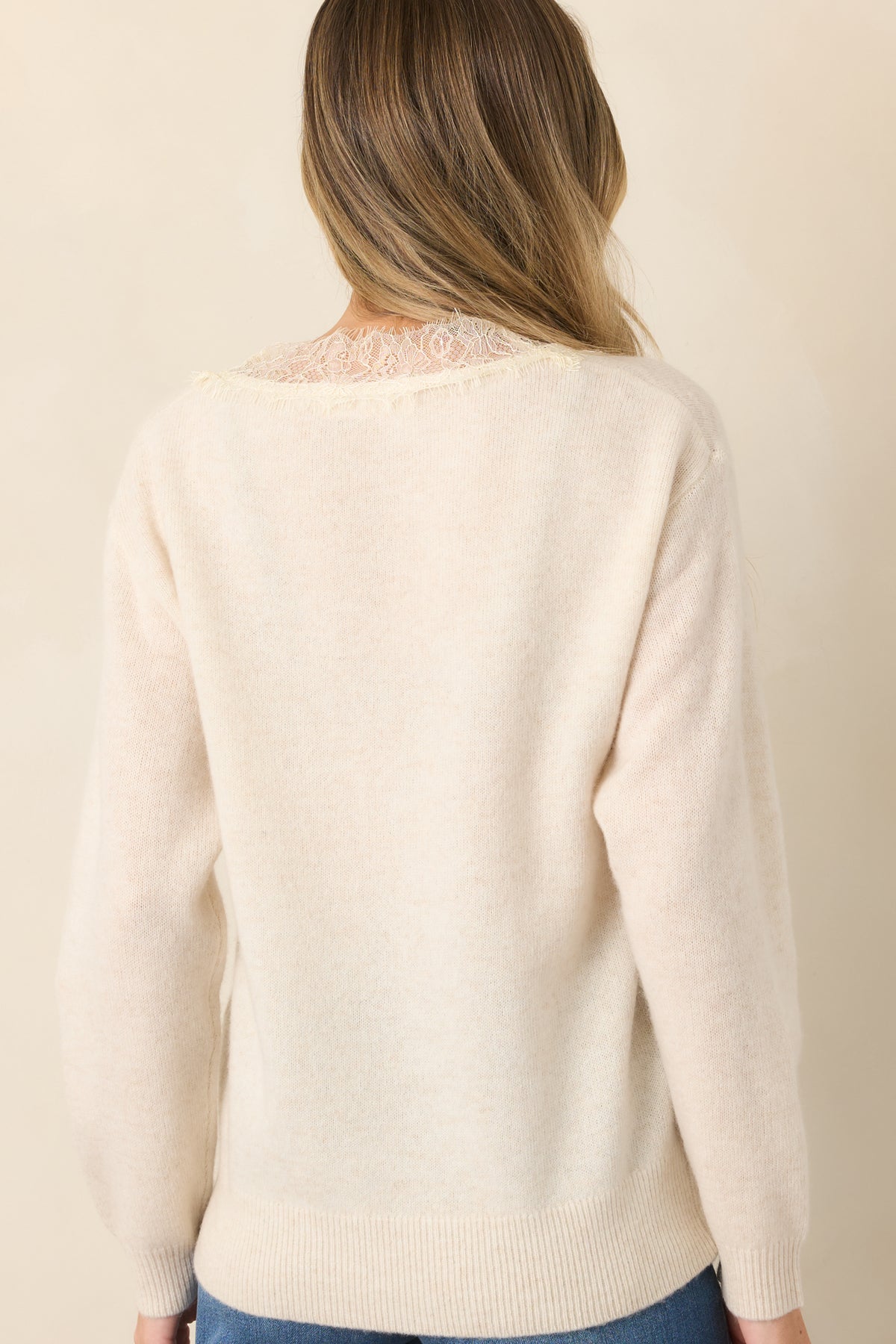 Rear of ivory wool sweater showcasing its soft knit silhouette.