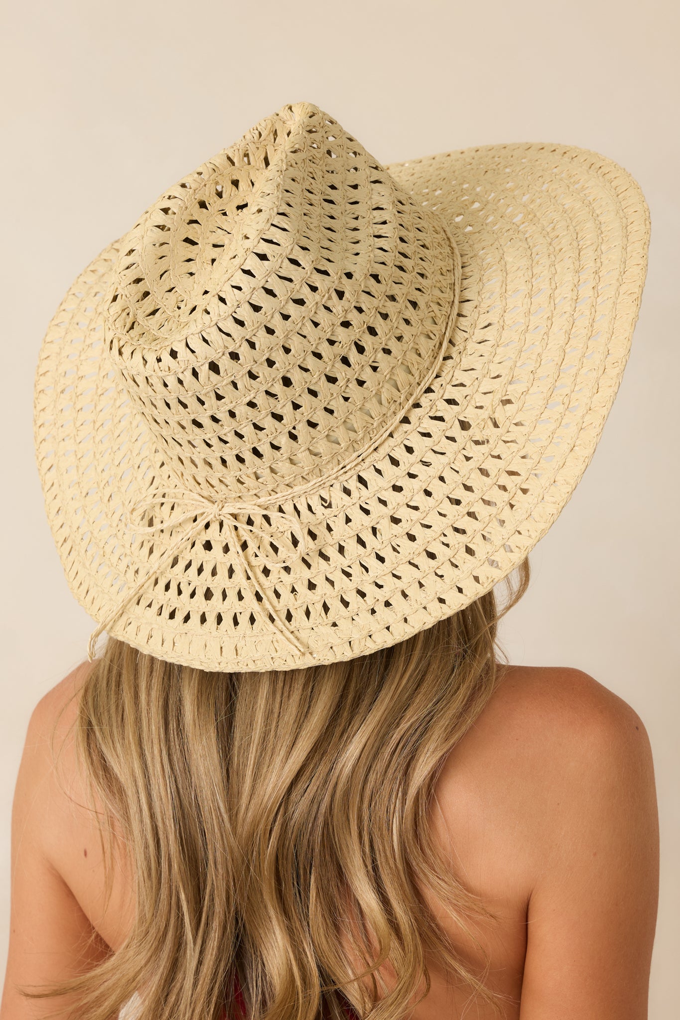 Ivory woven cowboy hat featuring a breathable open-weave straw design, structured crown, and wide brim silhouette.