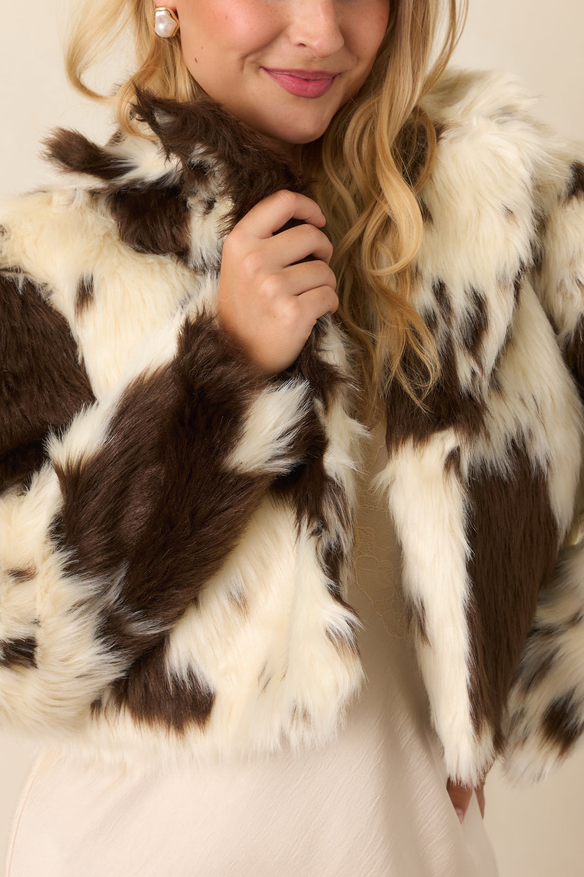 Close-up of the jacket’s oversized collar and single snap-button closure against the smooth fabric.