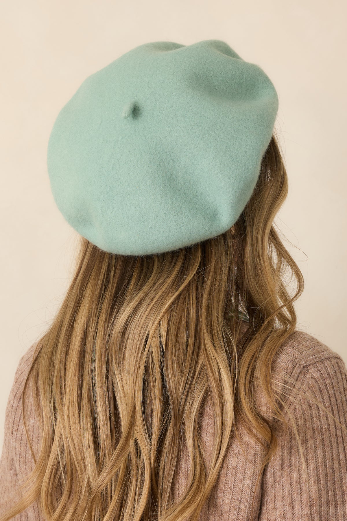 Rear view of the jade green wool beret showing its rounded shape and smooth structured finish.
