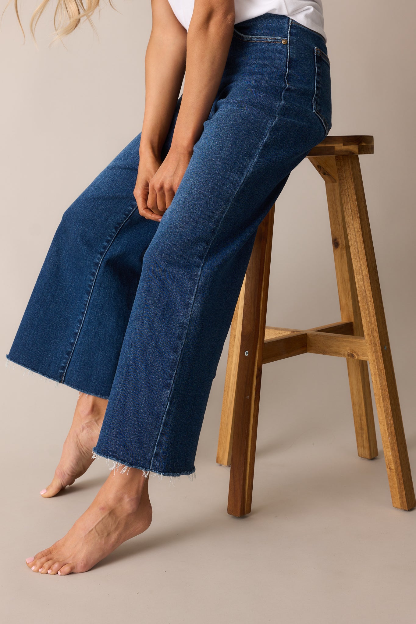 A detailed view of the jeans’ wide-leg cut, emphasizing the slightly cropped length and raw bottom hem.