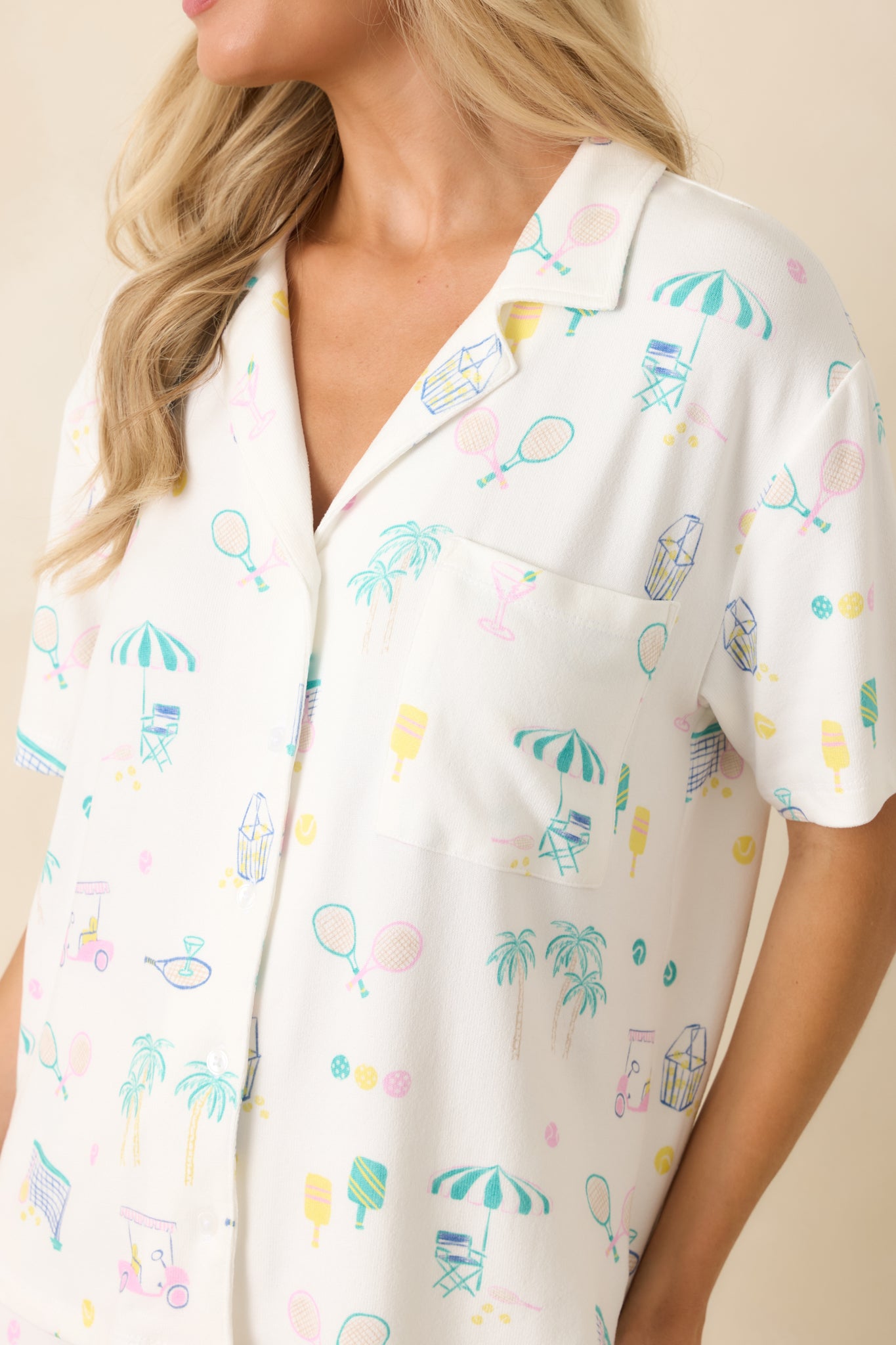 Close-up of the soft jersey knit fabric showcasing the multi-sport and resort-inspired print, button detailing, and chest pocket.