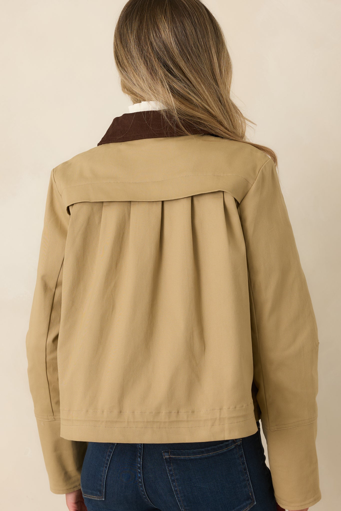 Rear view of the khaki jacket featuring back pleat detailing, relaxed fit, and slightly cropped silhouette.