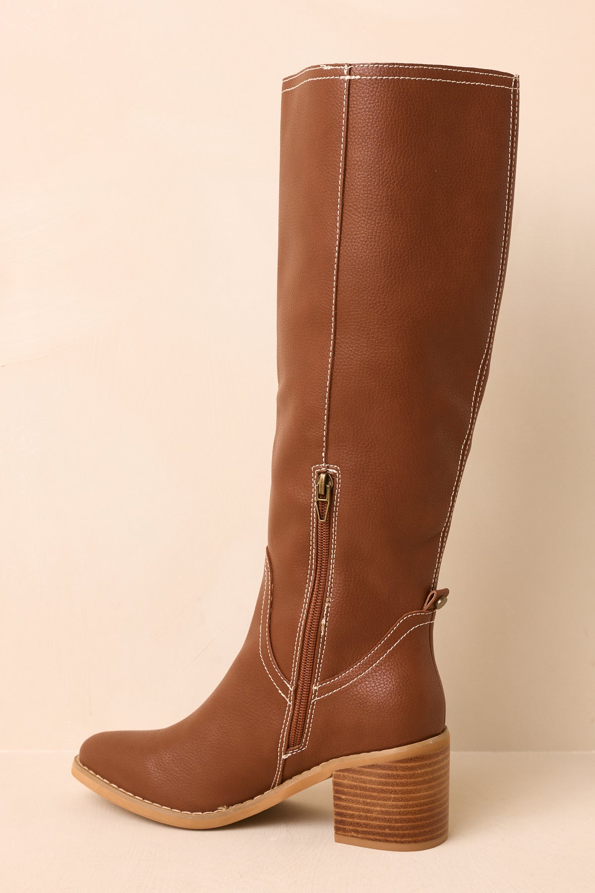 Side view highlights the stacked heel, smooth almond toe, and interior side zipper on the knee-high boots.
