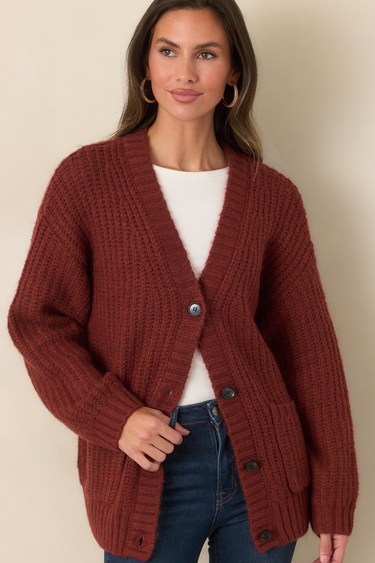 Knit cardigan featuring dark front buttons, a relaxed V-neckline, and wide ribbed trim along the neckline and cuffs.