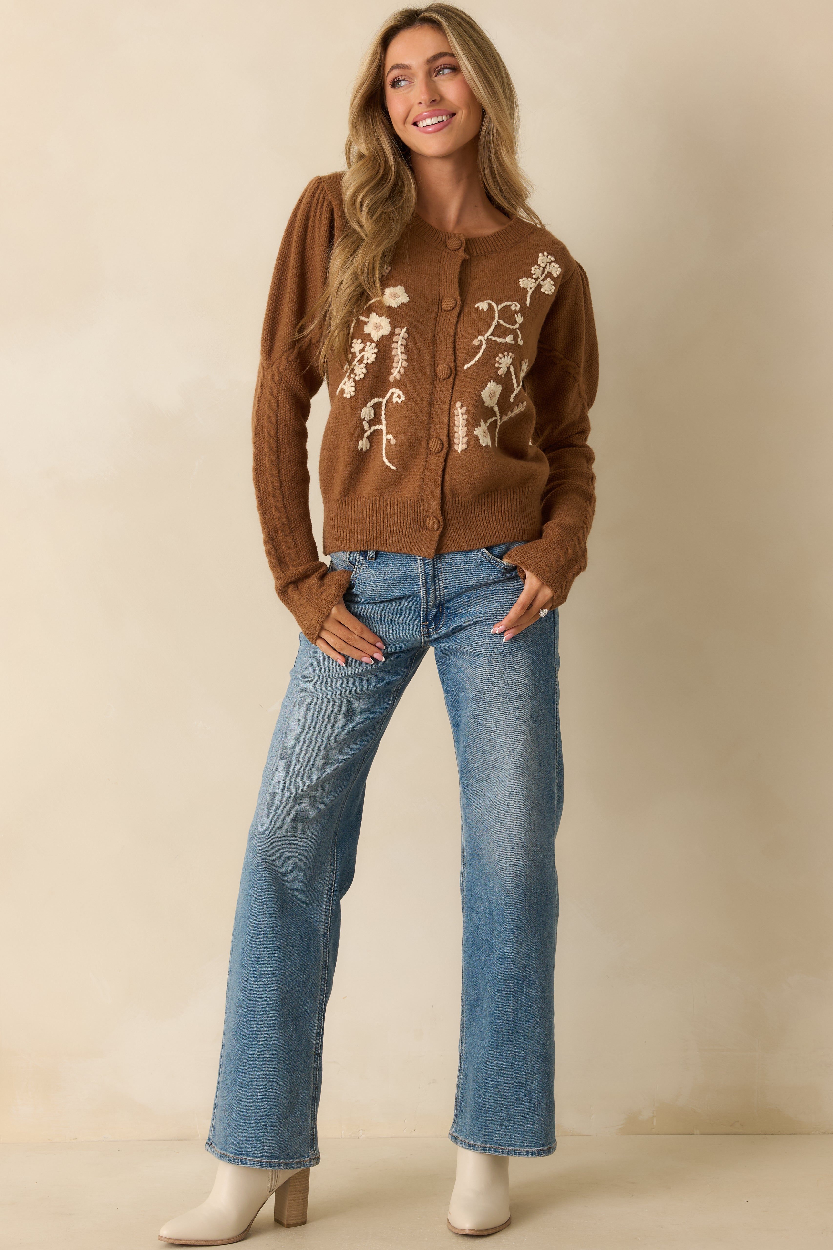 Knit cardigan featuring long sleeves, ribbed cuffs and hem, and delicate cream floral detailing.