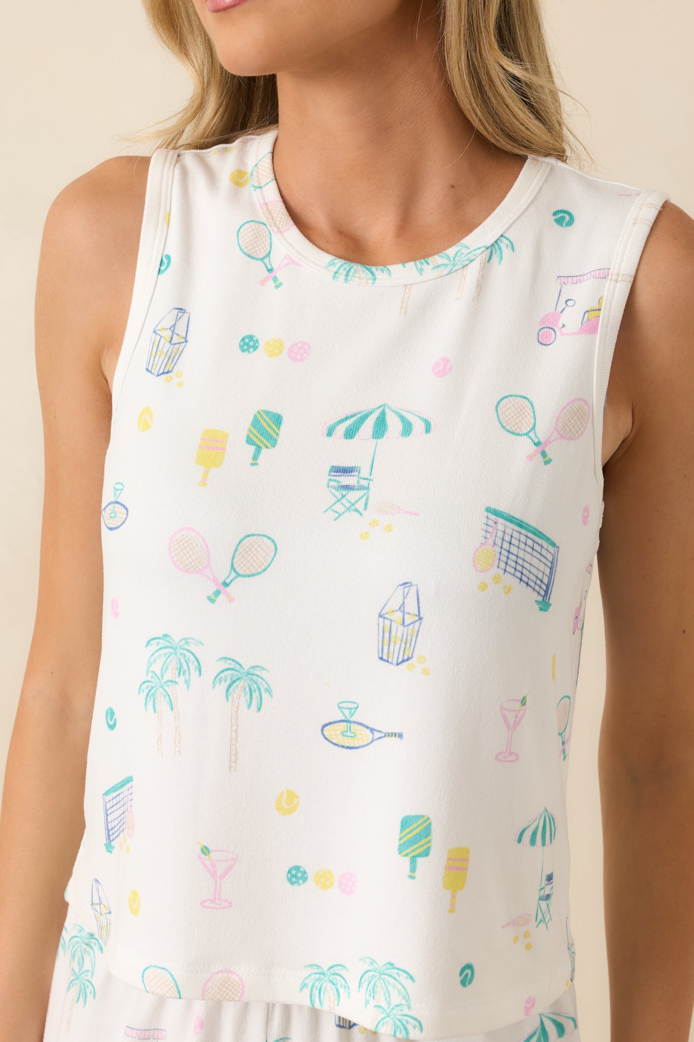 Close-up of the lightweight knit fabric showing the colorful allover print with tennis, pickleball, palm trees, and cocktail-themed illustrations.