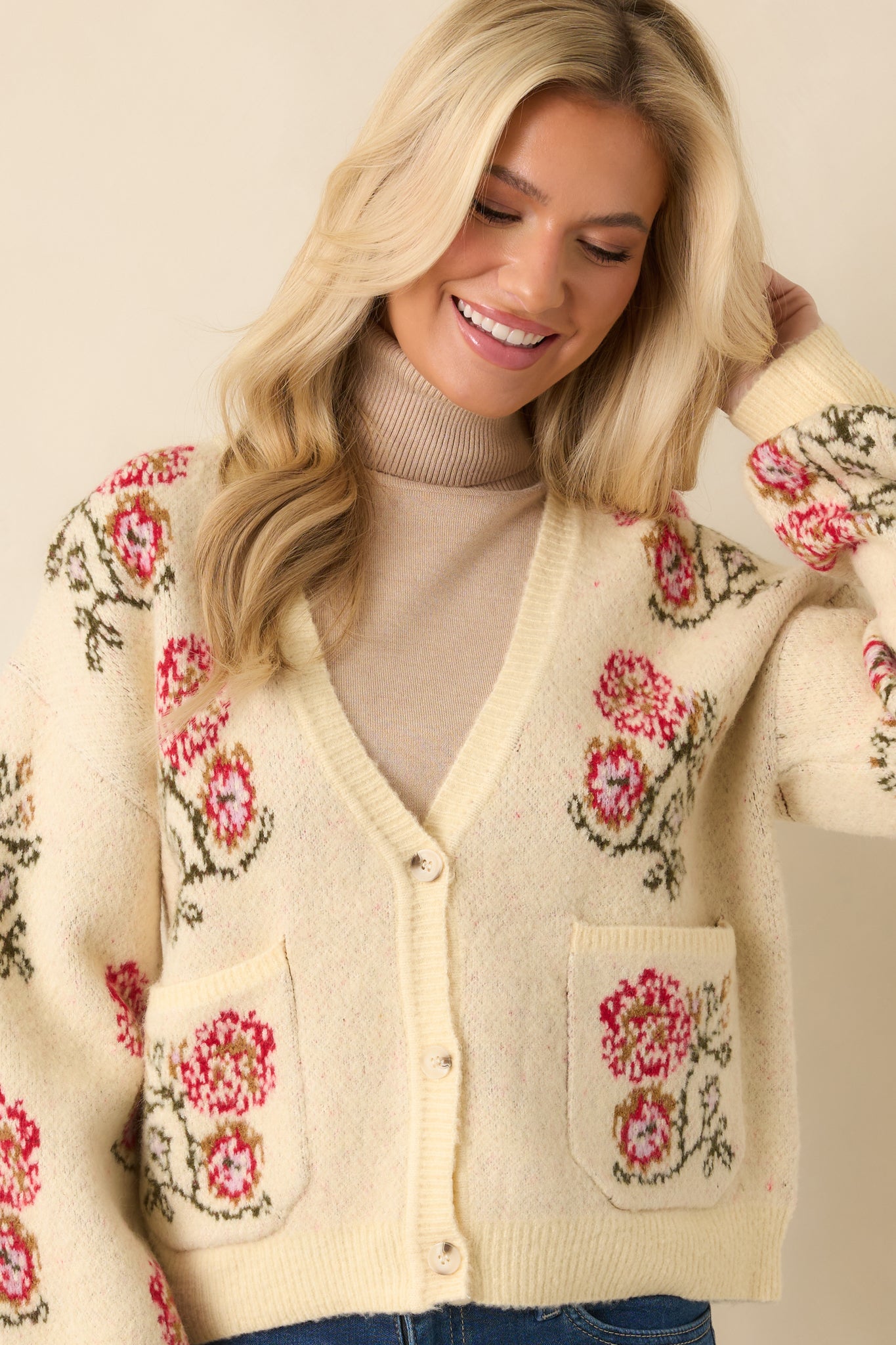 Knit texture showing the smooth ivory yarn and delicate floral accents on the pocket.