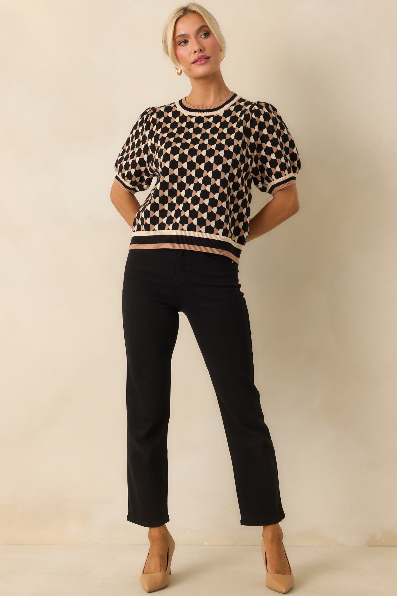 Knit top featuring allover geometric pattern, short puff sleeves, crew neckline, and relaxed cropped fit.