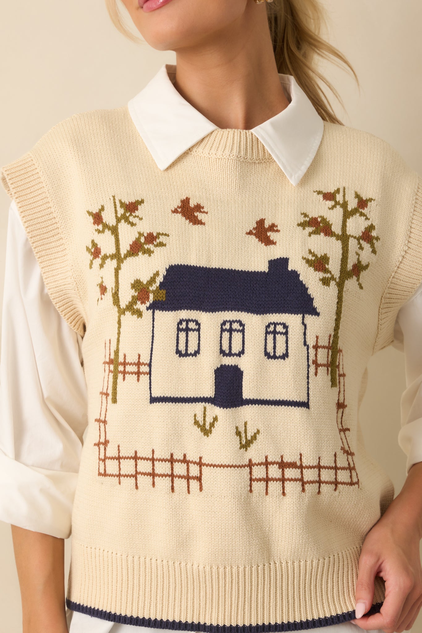 Detailed shot of the house and tree motif with ribbed hem texture and navy trim.