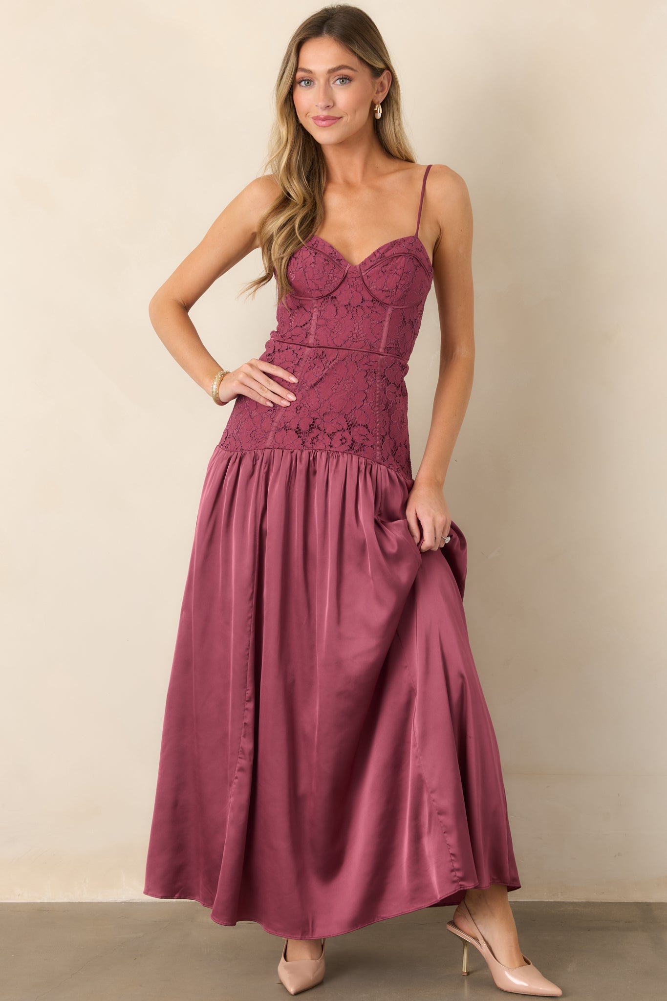 Lace-covered bodice and satin maxi dress featuring a sweetheart neckline, slim adjustable straps, fitted bustier silhouette, dropped waist, and gathered skirt.