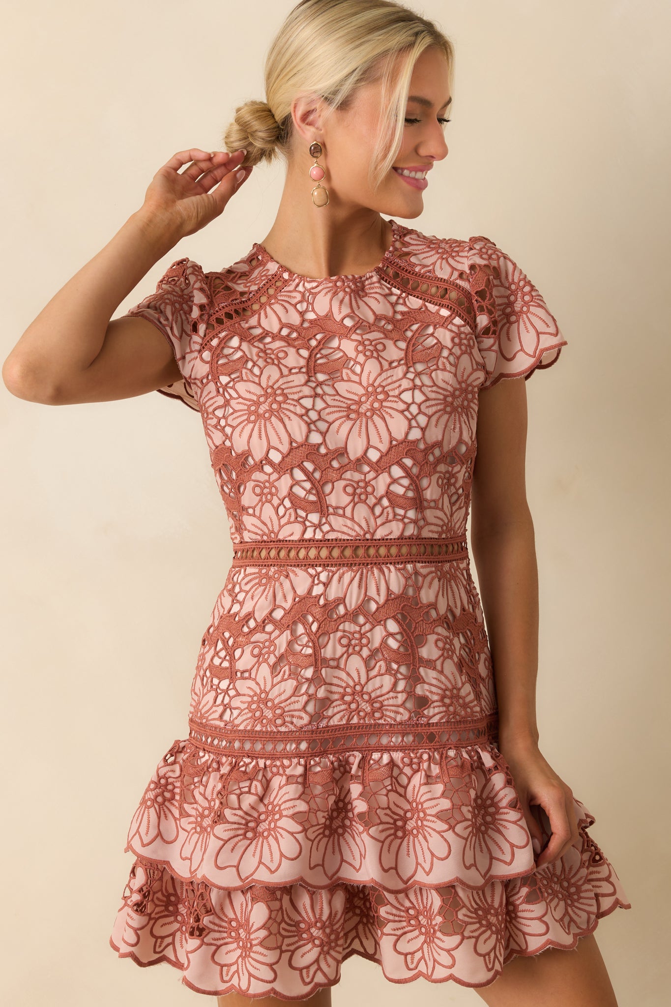 Detail of the lace overlay with subtle terracotta and pink floral accents.