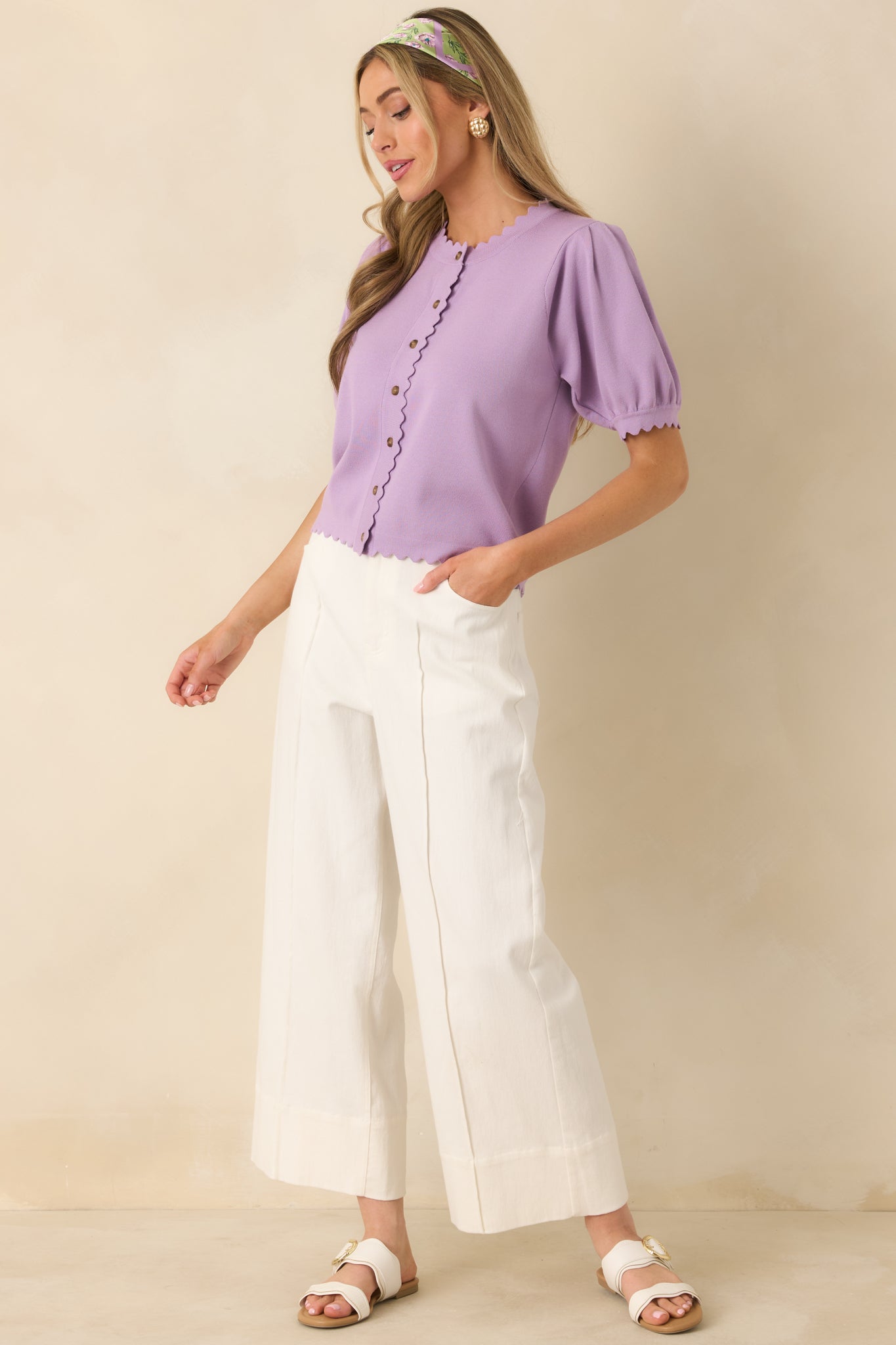 Lavender knit cardigan shown from the front highlighting round neckline and short puff sleeves.