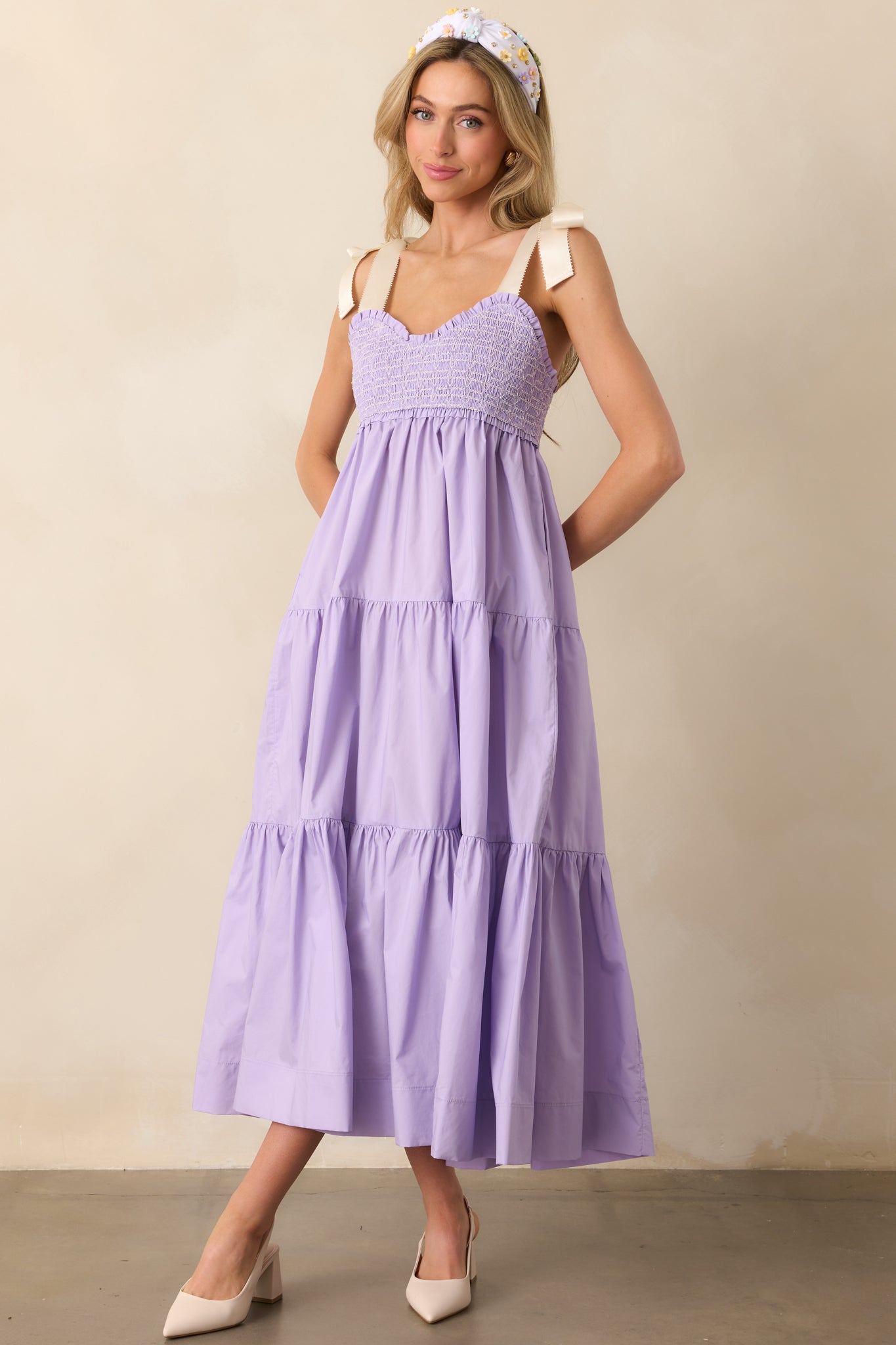 The perfect mix of style and comfort, this lavender midi dress features embroidered smocking, bow-tied straps, and a relaxed silhouette.
