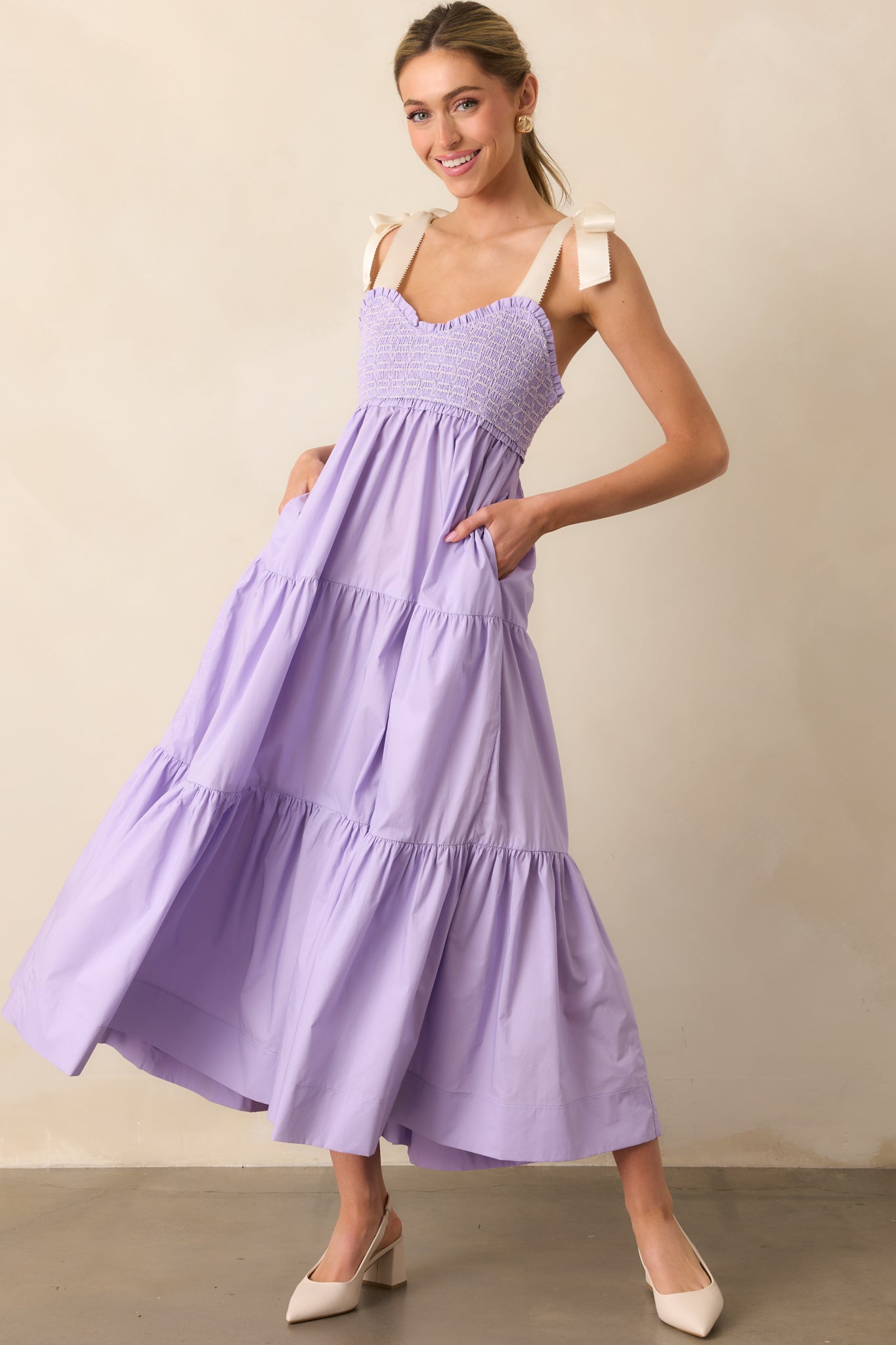  This lavender midi dress features a sweetheart neckline, embroidered smocked bust, and a flowing skirt with hidden pockets for effortless charm.