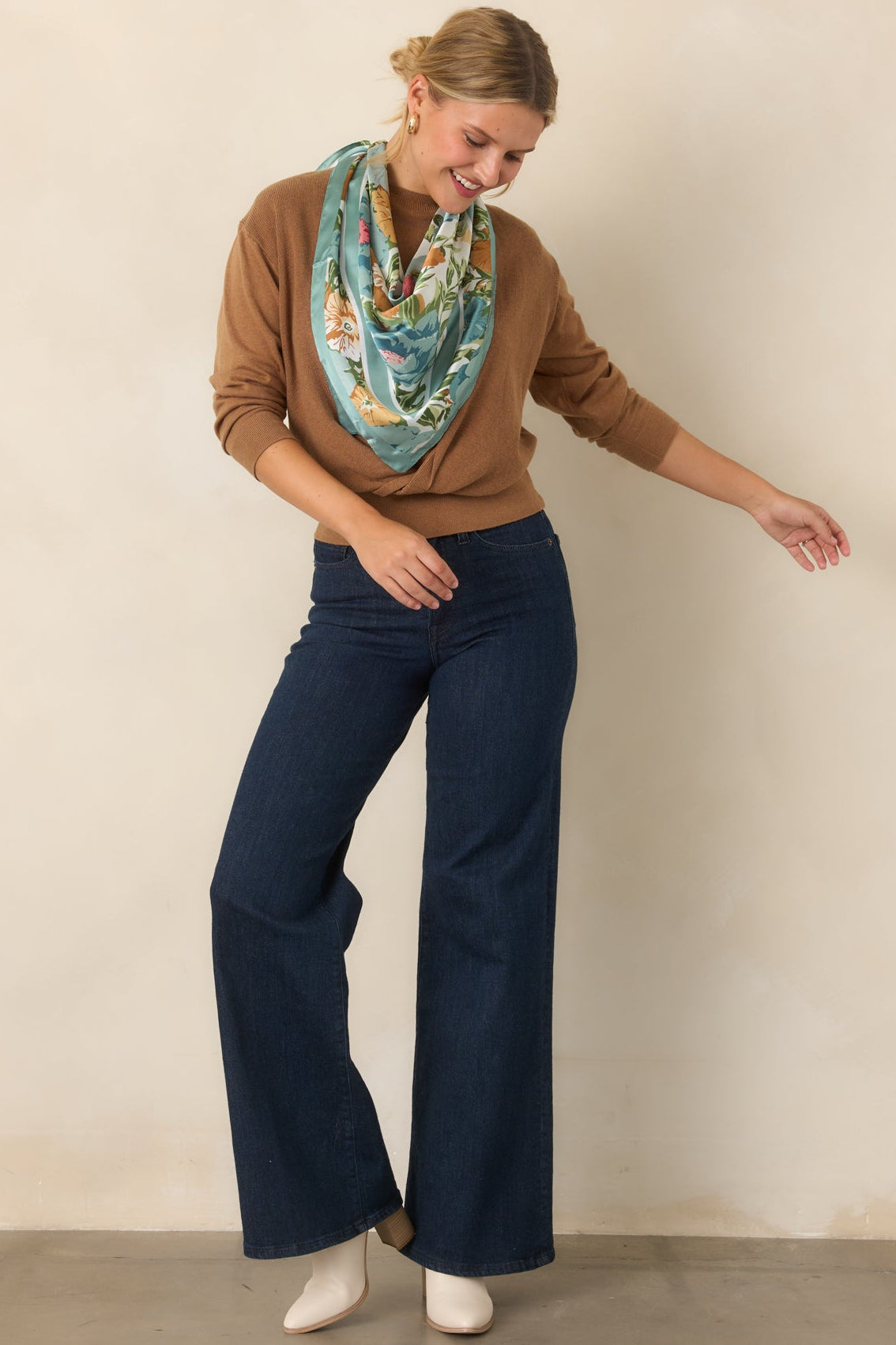 Layered knit top showcasing the twisted front overlay, sleeveless sweater base, and defined ribbed waist.