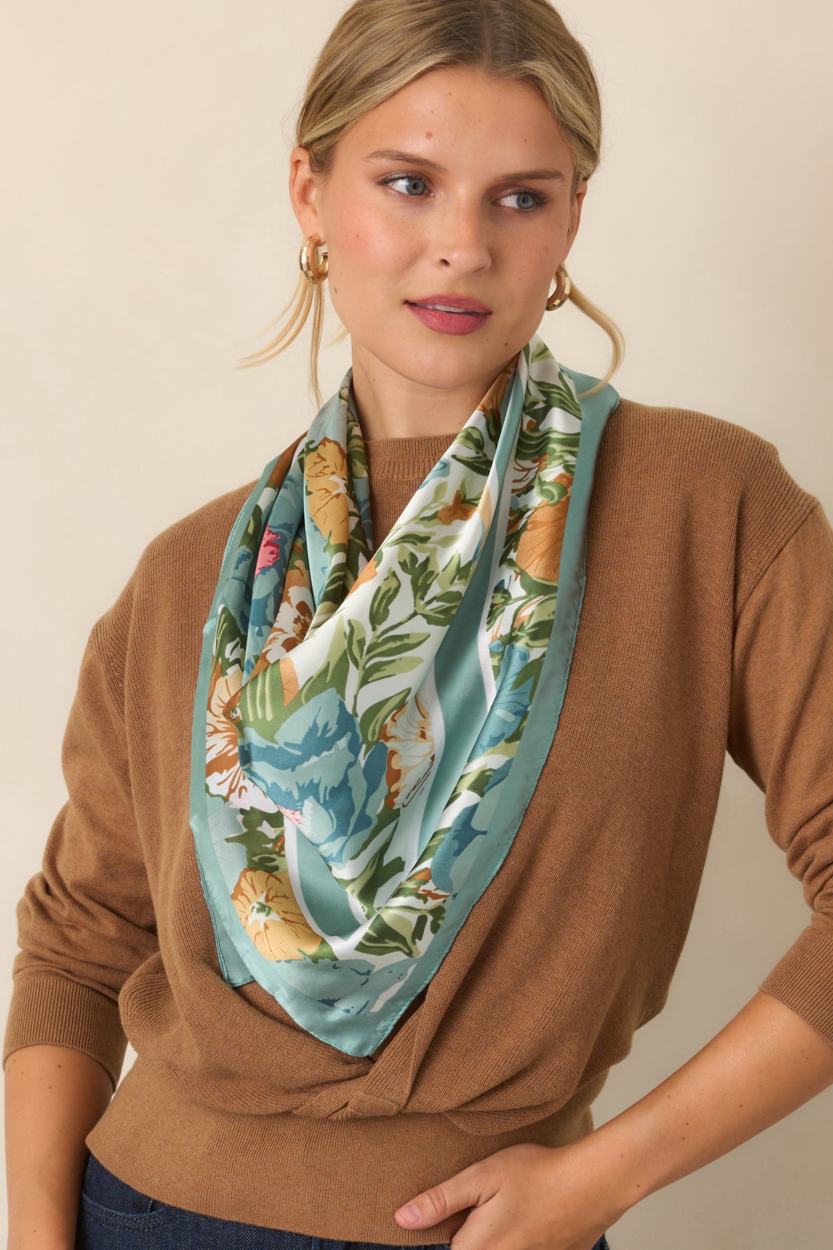 Close view of the layered sweater design with its twisted front and wide ribbed hem.