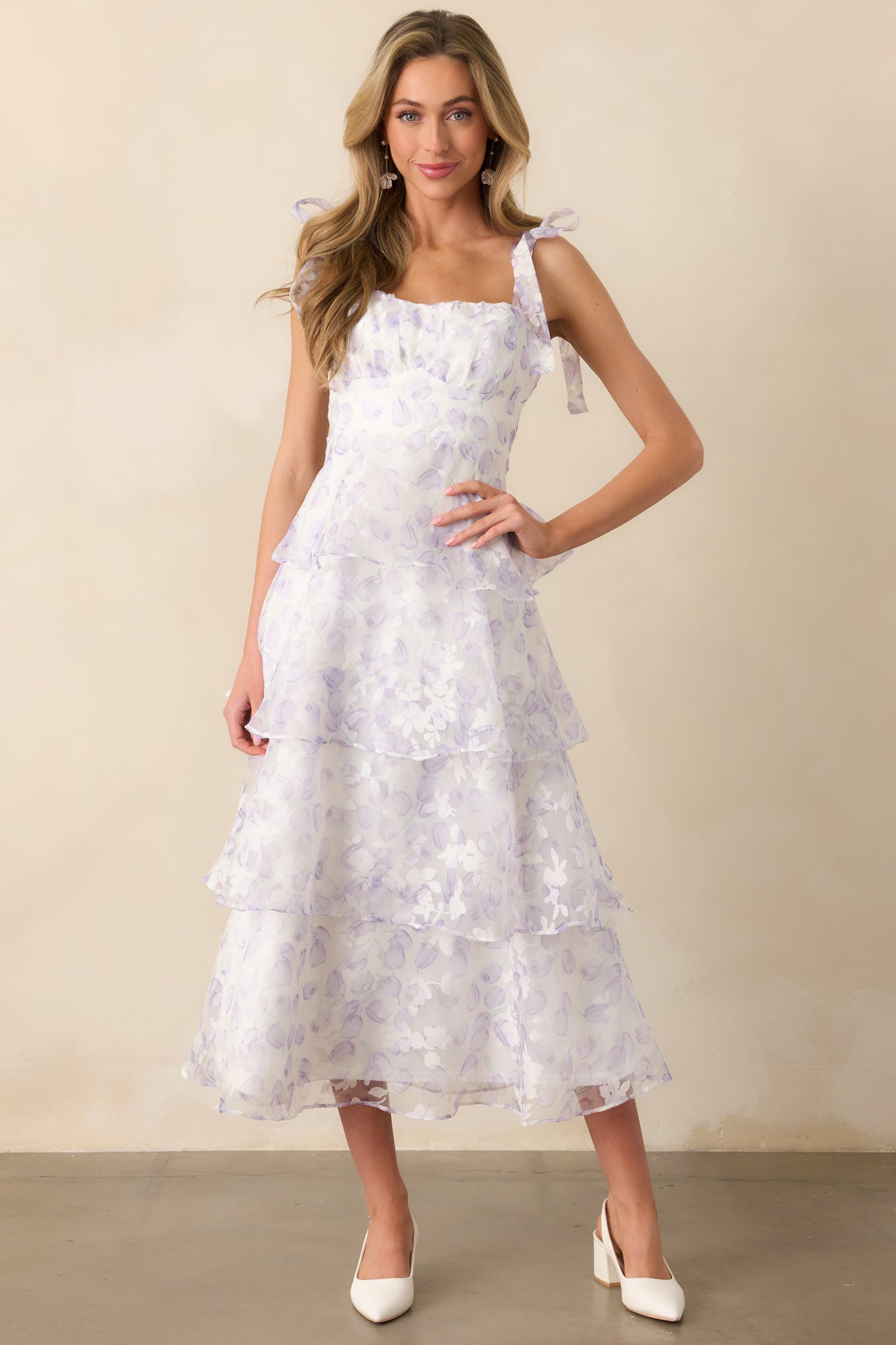 The lower portion of a lavender midi dress, showcasing the layered tulle skirt with a tiered structure, intricate floral details, and a soft flowing hemline.
