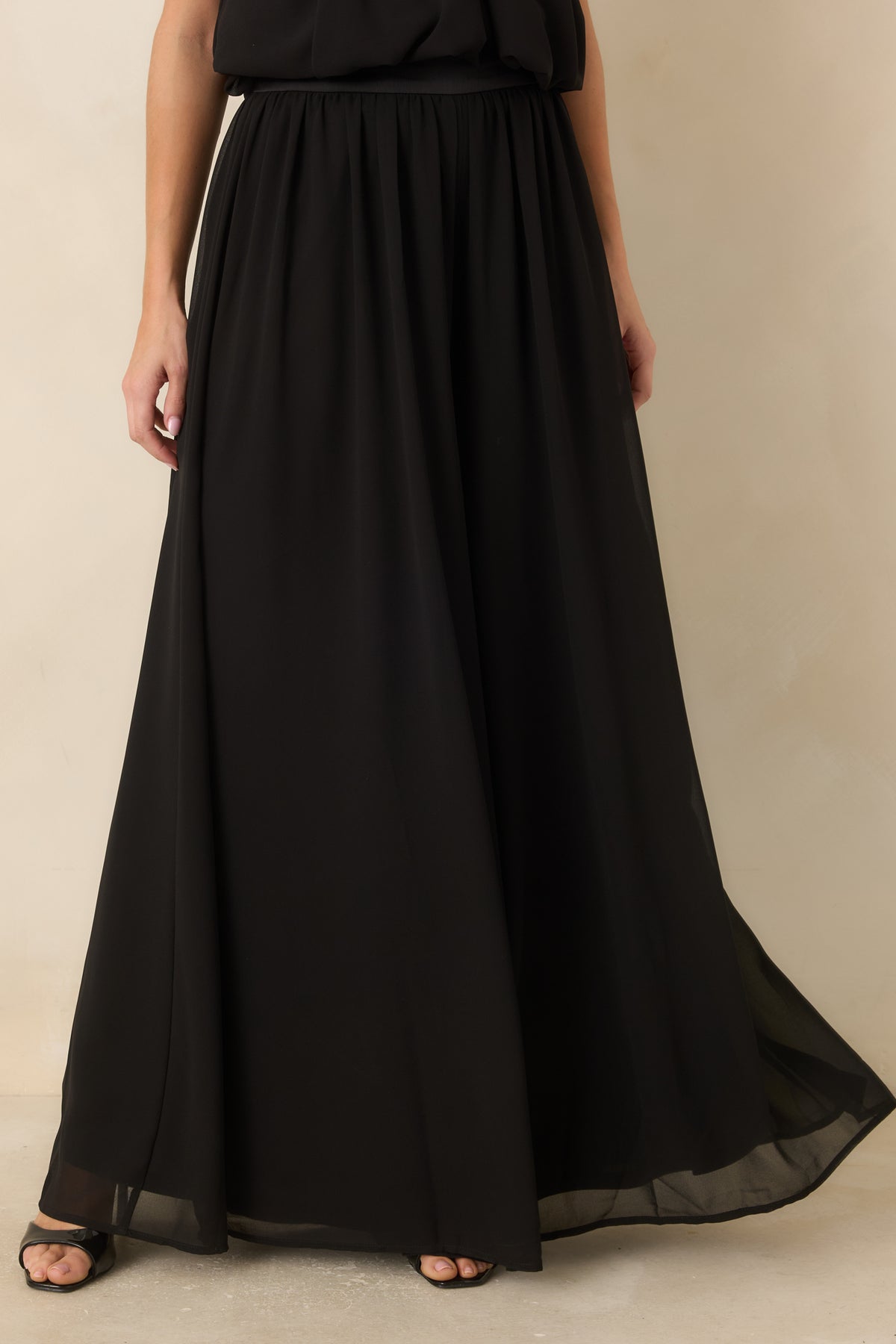 Translucent outer layer draped over the opaque interior of the flowing pants