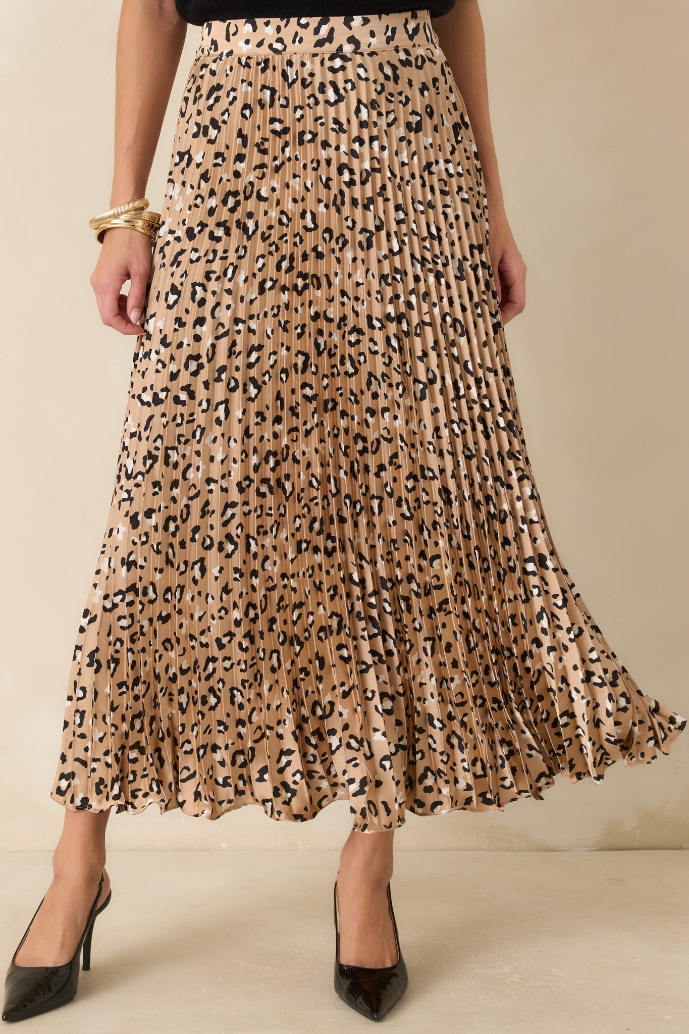 Partial view of the flowing maxi skirt featuring soft pleats and a sleek leopard print finish.