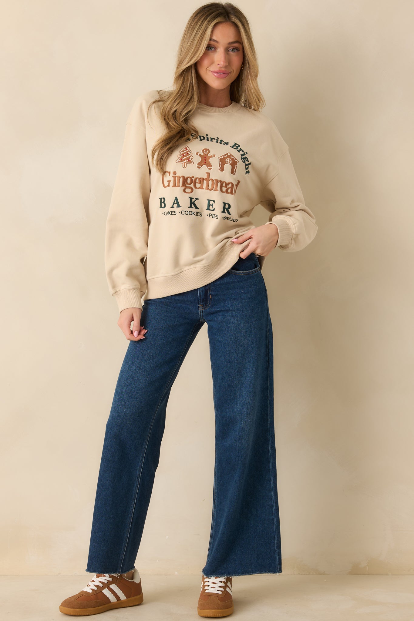 Light beige fleece sweatshirt featuring the embroidered gingerbread accents and cozy crew neckline.