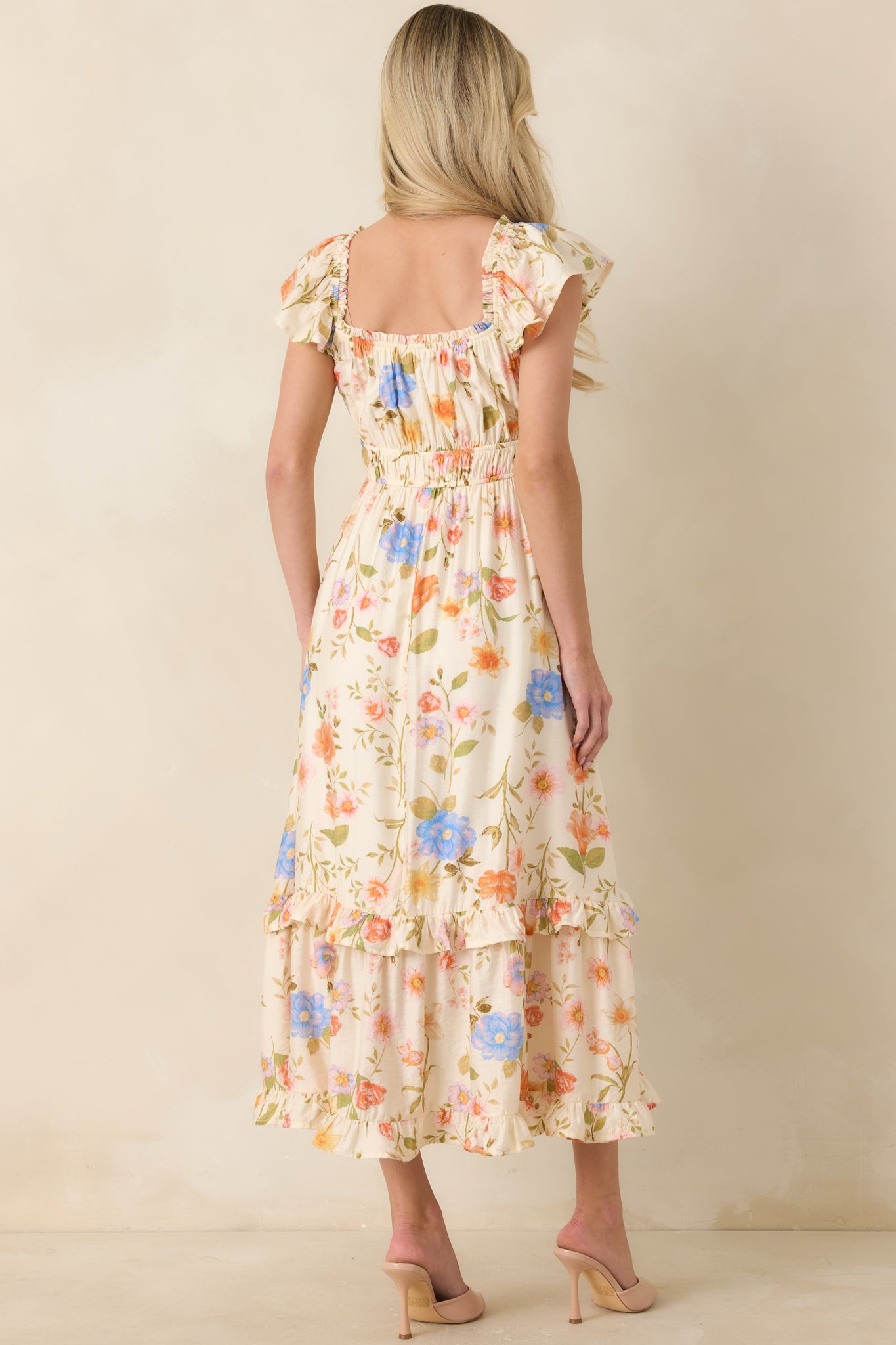 Rear view of light beige multi floral midi dress with elastic waist and tiered ruffled skirt.