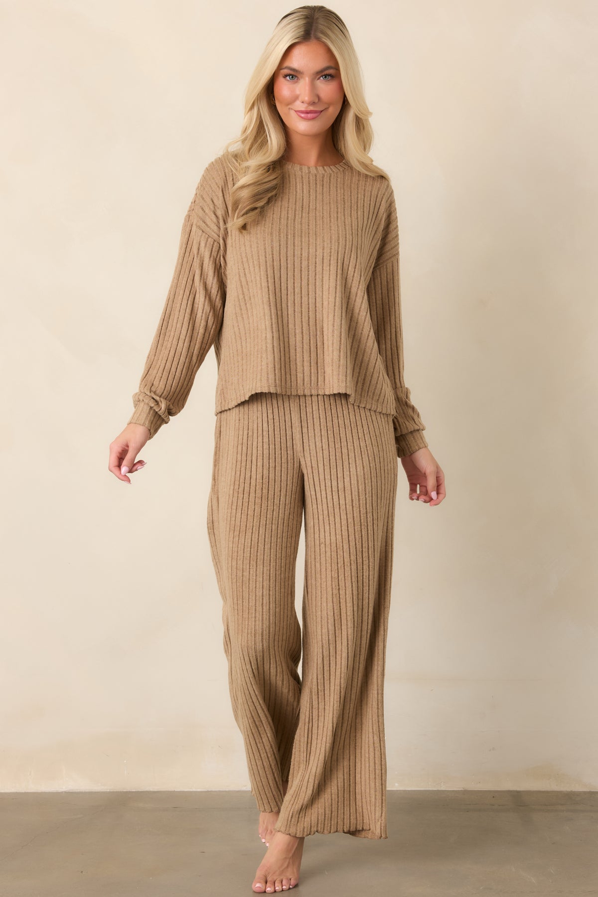 Light beige ribbed pants showcasing a high-rise smocked waist and softly draped wide-leg design.