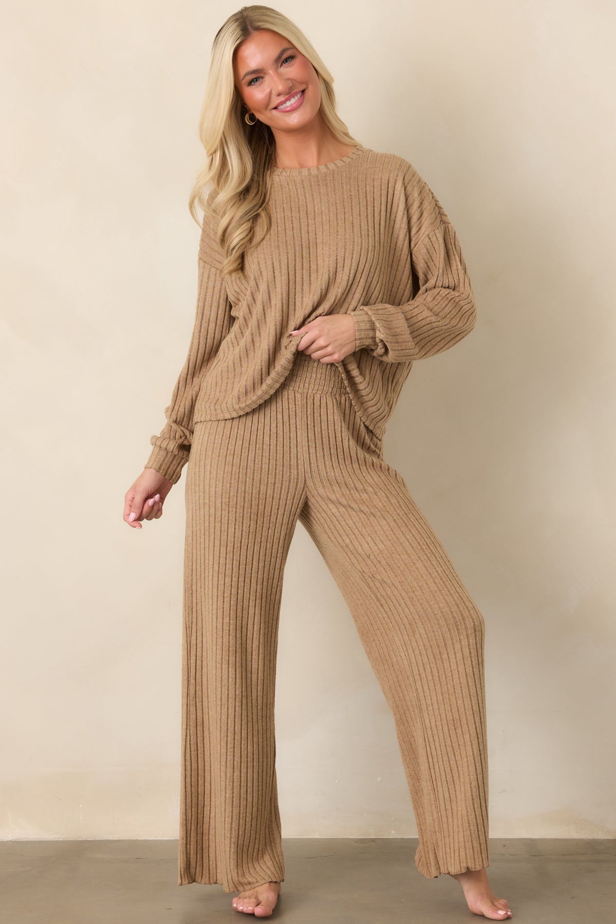 Light beige silky rib pants featuring a wide smocked waistband and fluid wide-leg silhouette with a soft, comfortable drape.