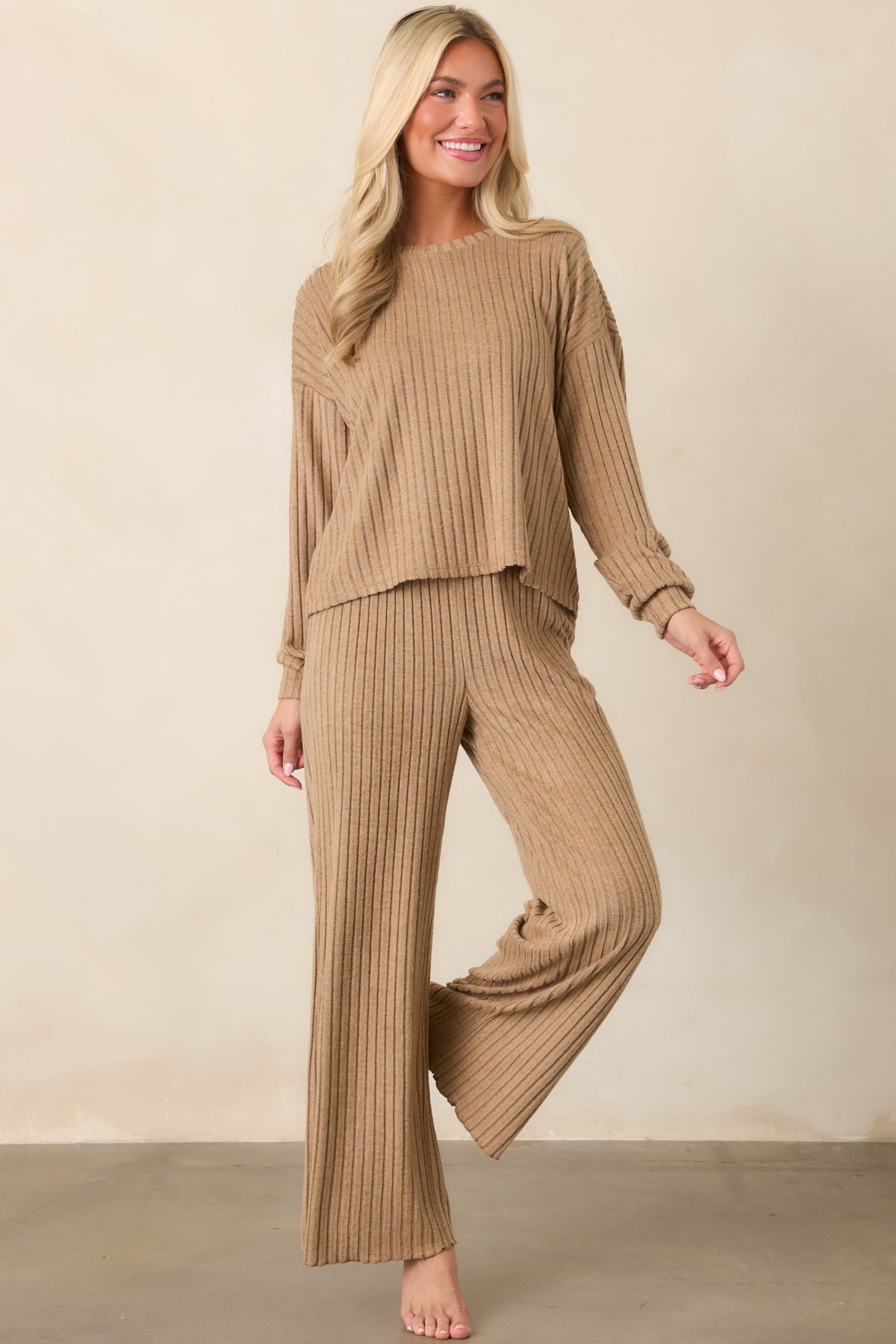 Light beige pants crafted from silky rib fabric with a high-rise smocked waistband and relaxed wide-leg silhouette.