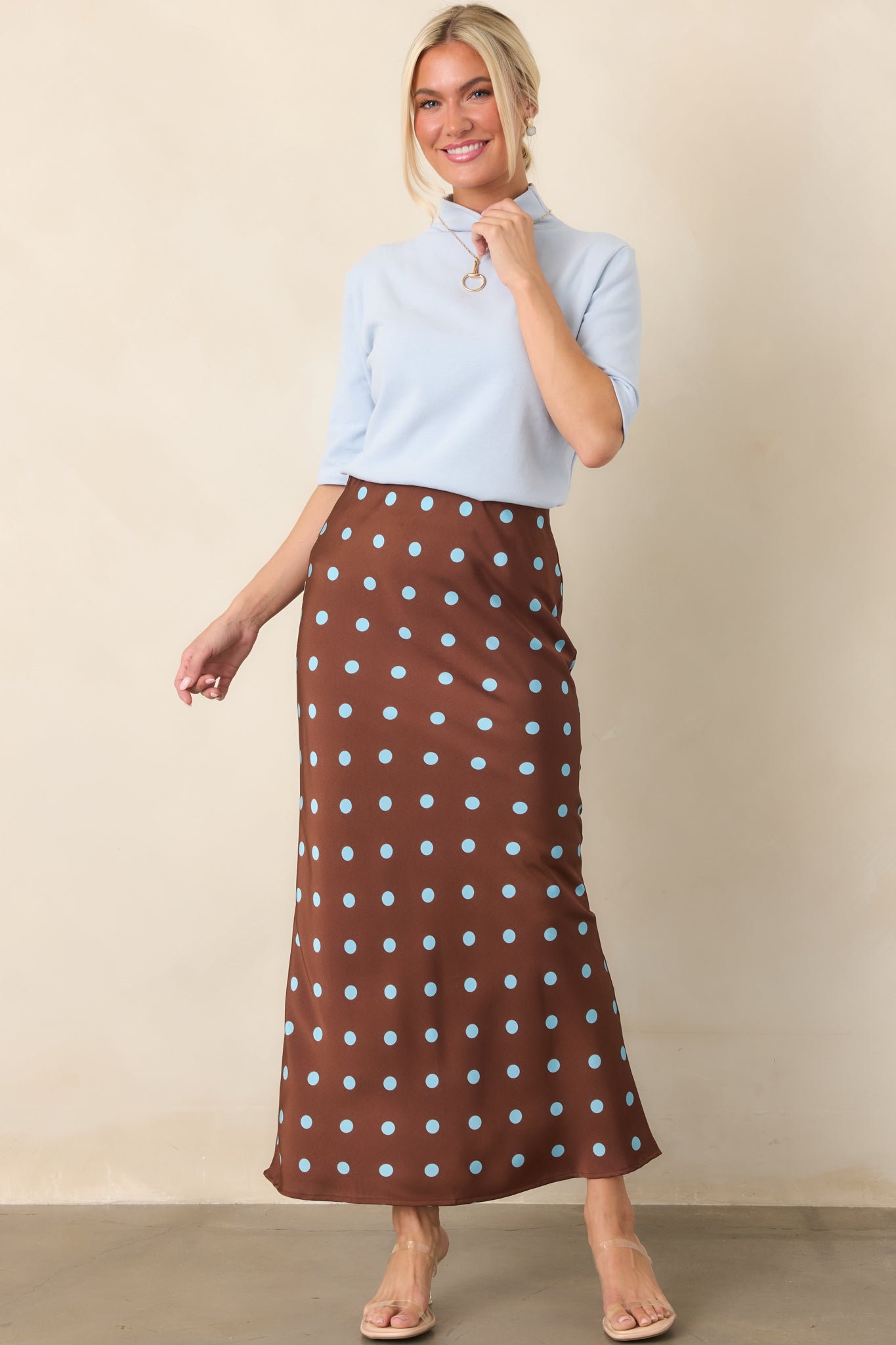 Fresh light blue knit shirt featuring a sleek high neckline, tailored fit, and softly structured elbow-length sleeves.