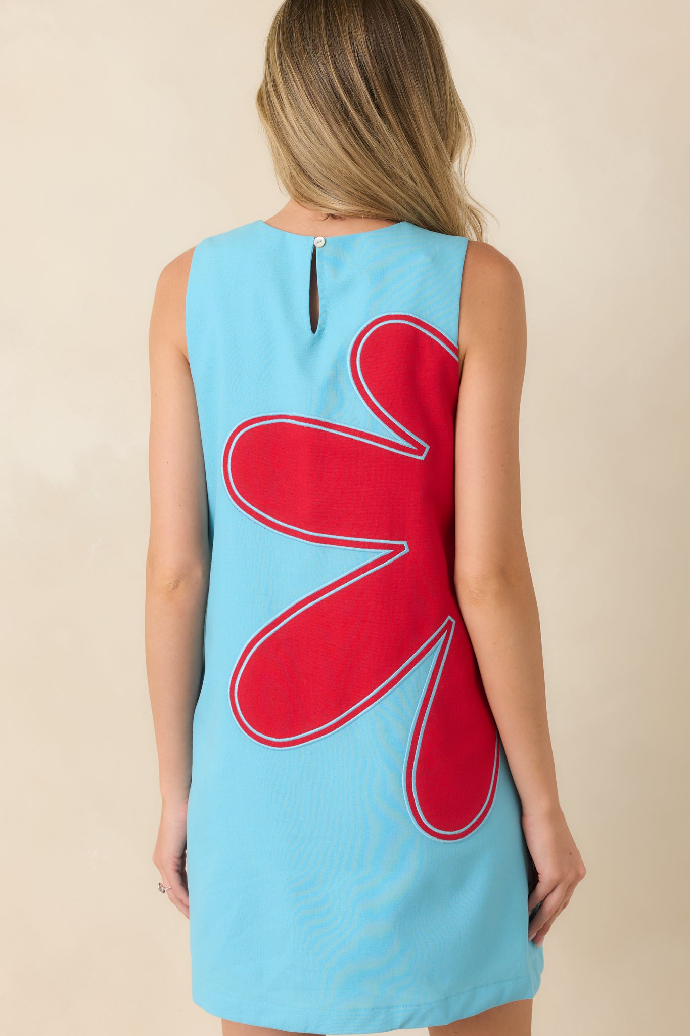Rear view of the light blue shift dress featuring a keyhole closure, sleeveless design, and relaxed lined silhouette.