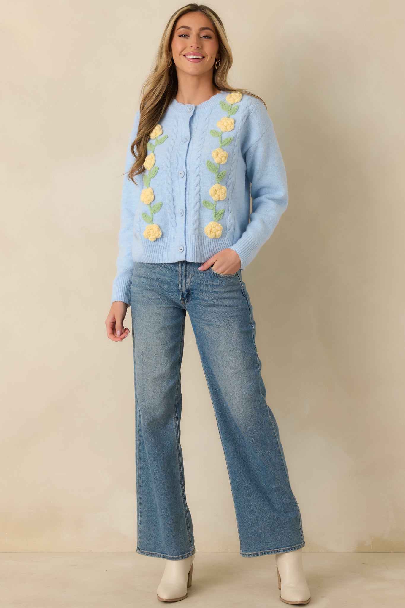Front view of light blue knit cardigan with crew neckline, long sleeves, and button-front closure.