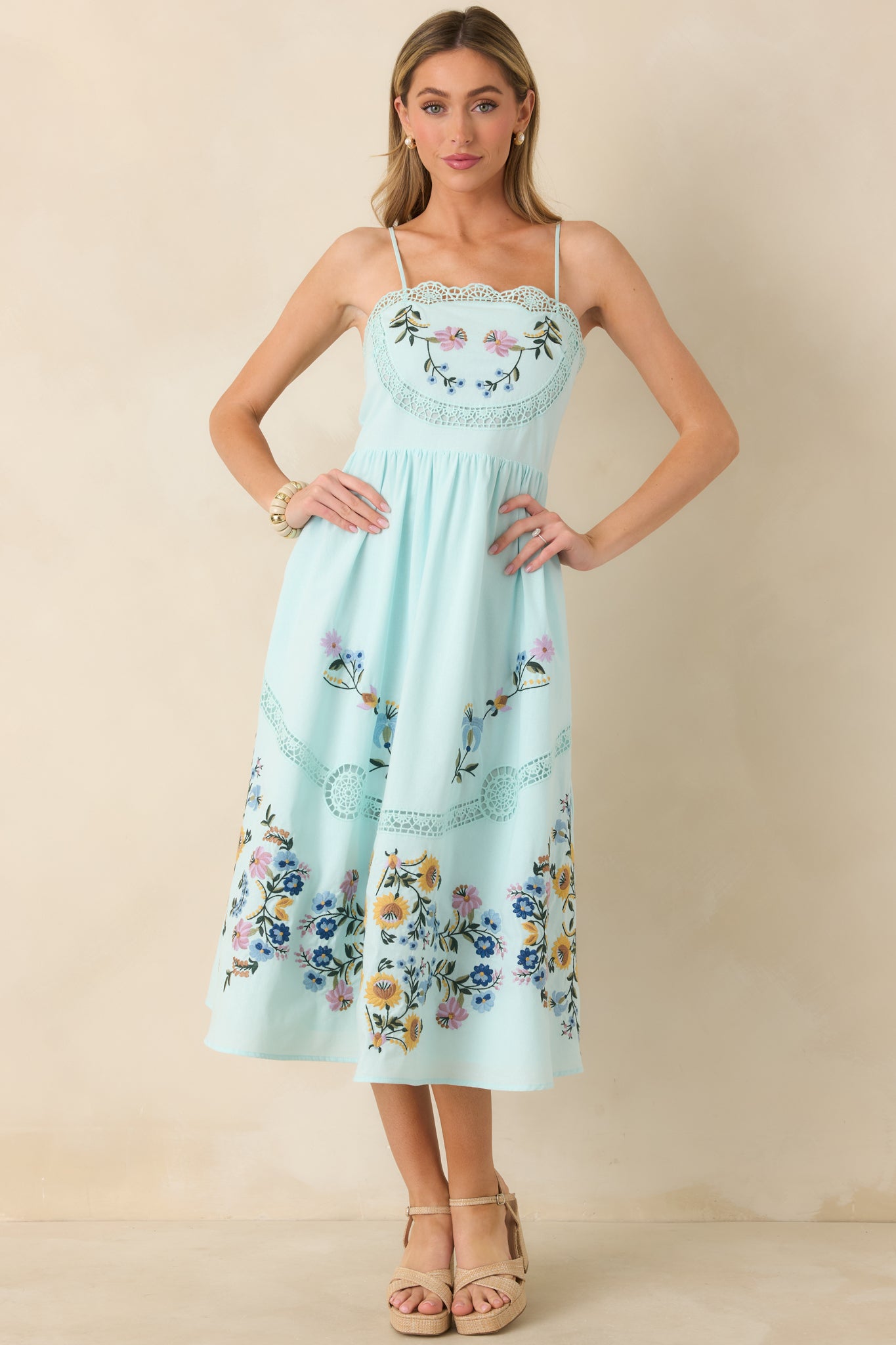 Light blue lace and embroidered dress with structured bodice, flowing skirt, and functional side pockets.