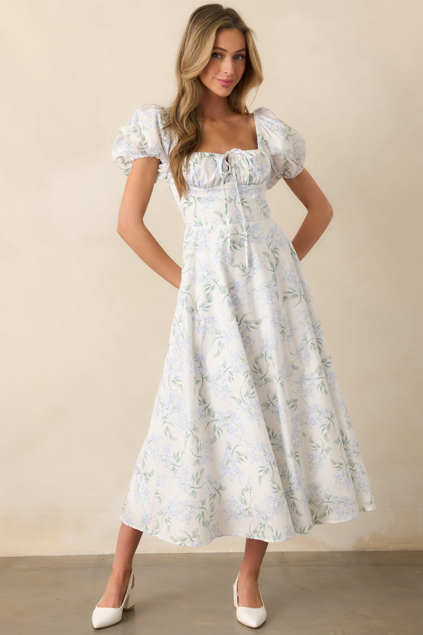 Front view of the light blue maxi dress with a floral print, featuring an elastic sweetheart neckline and bustier-style stitching. The dress includes short puff sleeves and elastic cuffs.
