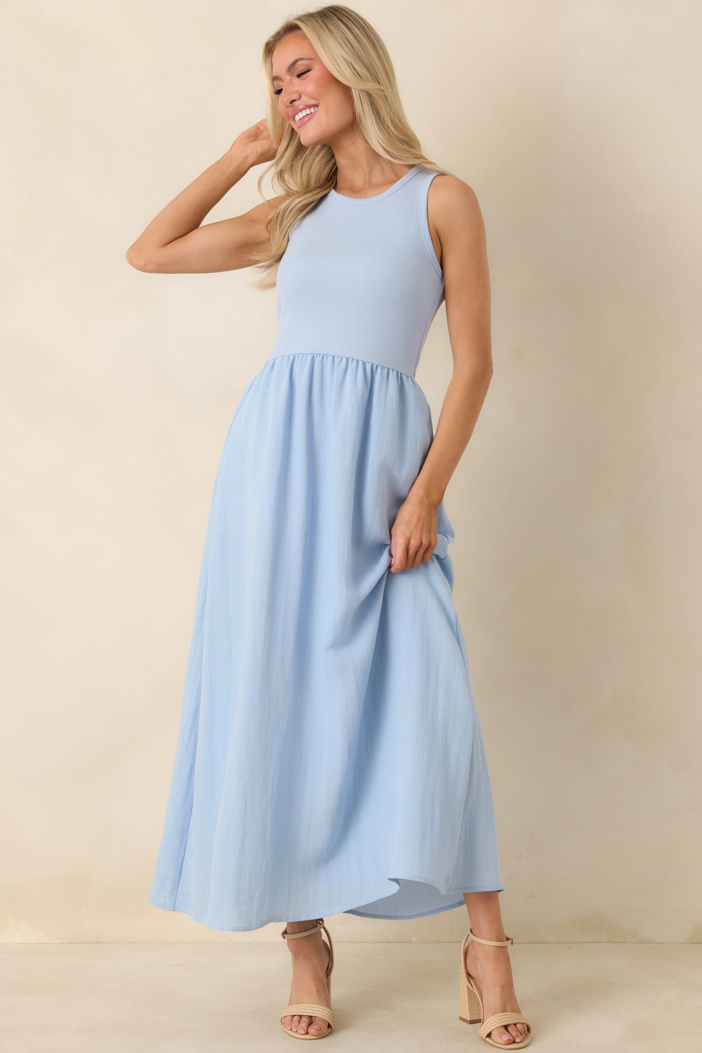 Light blue midi dress with a textured skirt and practical pockets, highlighting its casual, everyday silhouette.