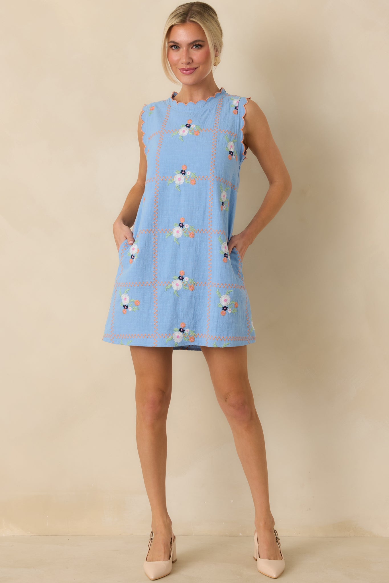Front view of a light blue mini dress with a round scalloped neckline, sleeveless silhouette, and relaxed straight fit.