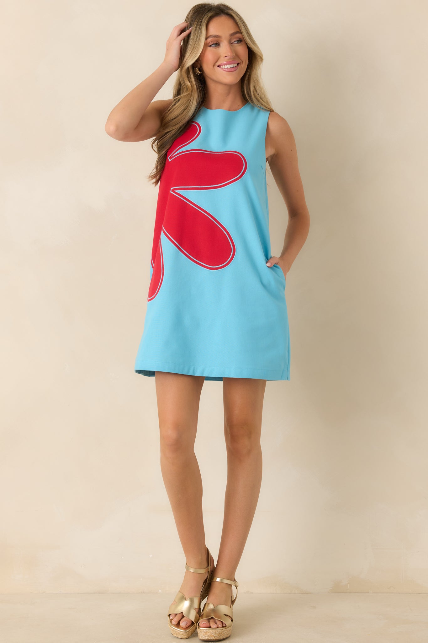 Light blue linen blend shift dress featuring oversized red floral appliqué, embroidered details, sleeveless design, and relaxed silhouette.