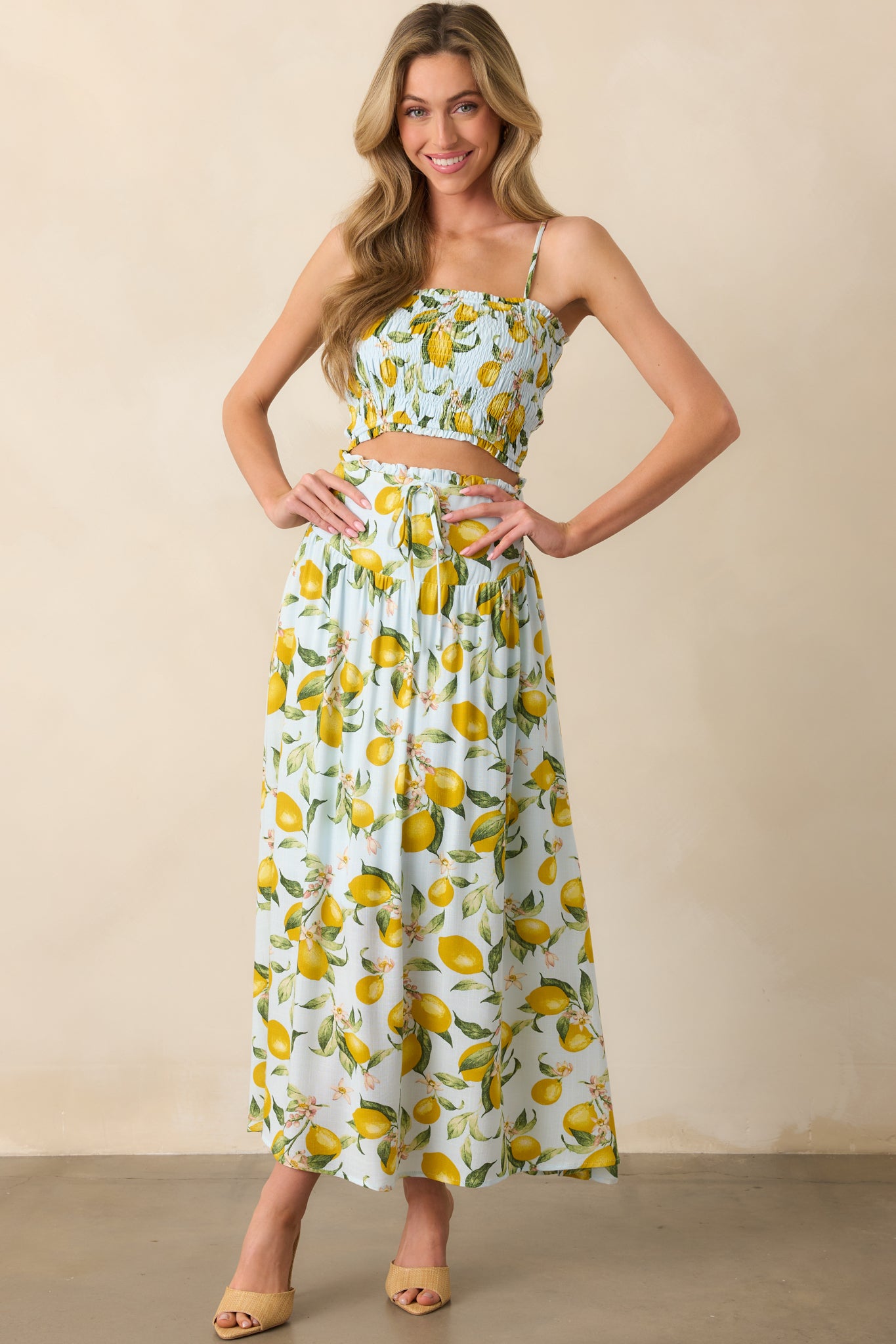 Full body view of light blue skirt with yellow and green lemon print, drop waist, and ruffle hem detail.