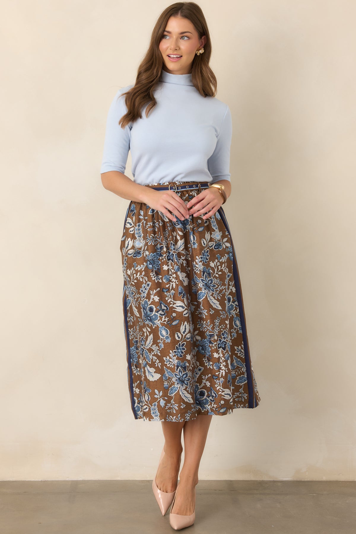 Polished light blue knit top designed with a smooth construction, mock neck, elbow-length sleeves, and clean, streamlined shape.
