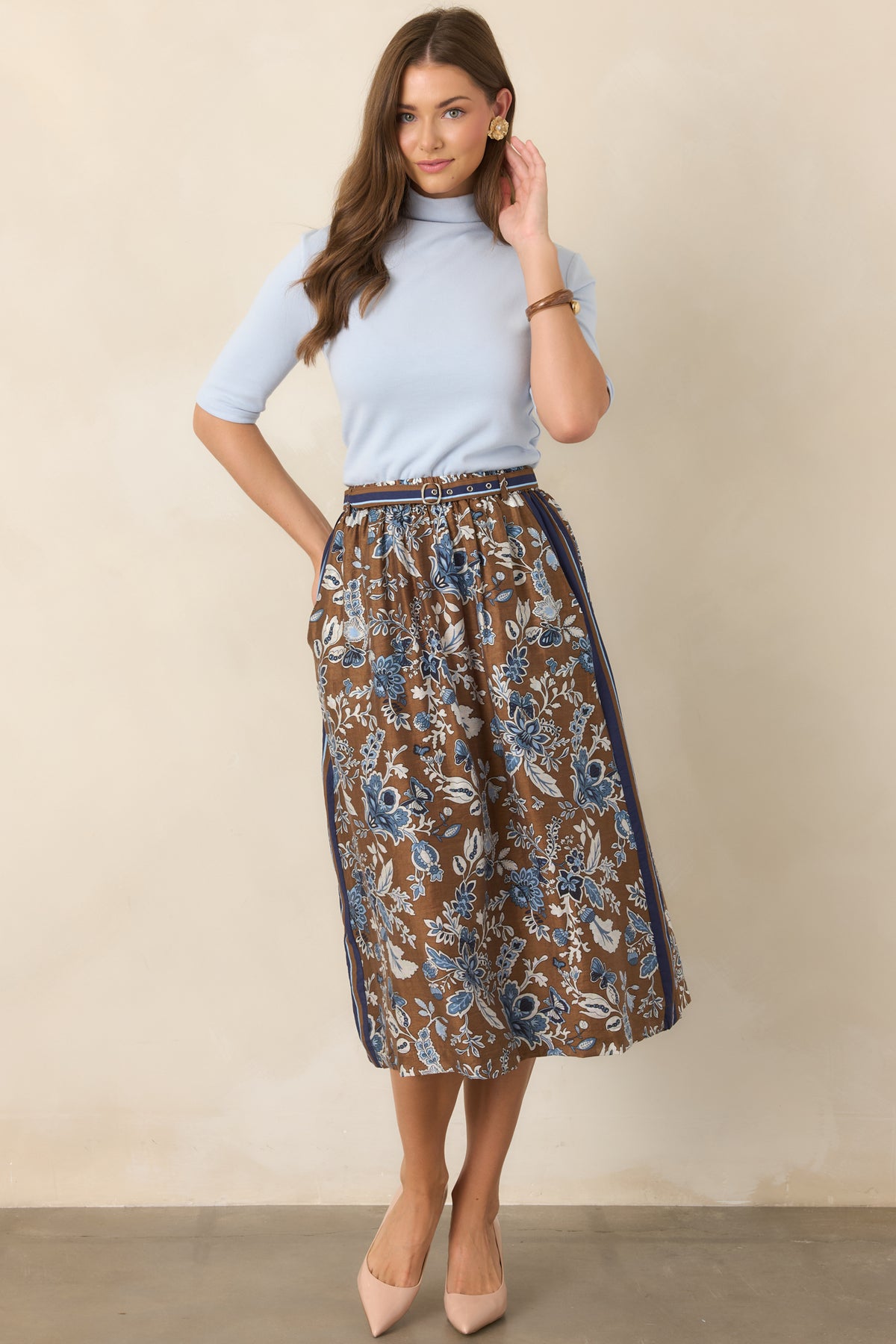 Light blue stretch knit top showcasing a softly structured mock neckline, fitted bodice, and sleeves that fall neatly to the elbows.