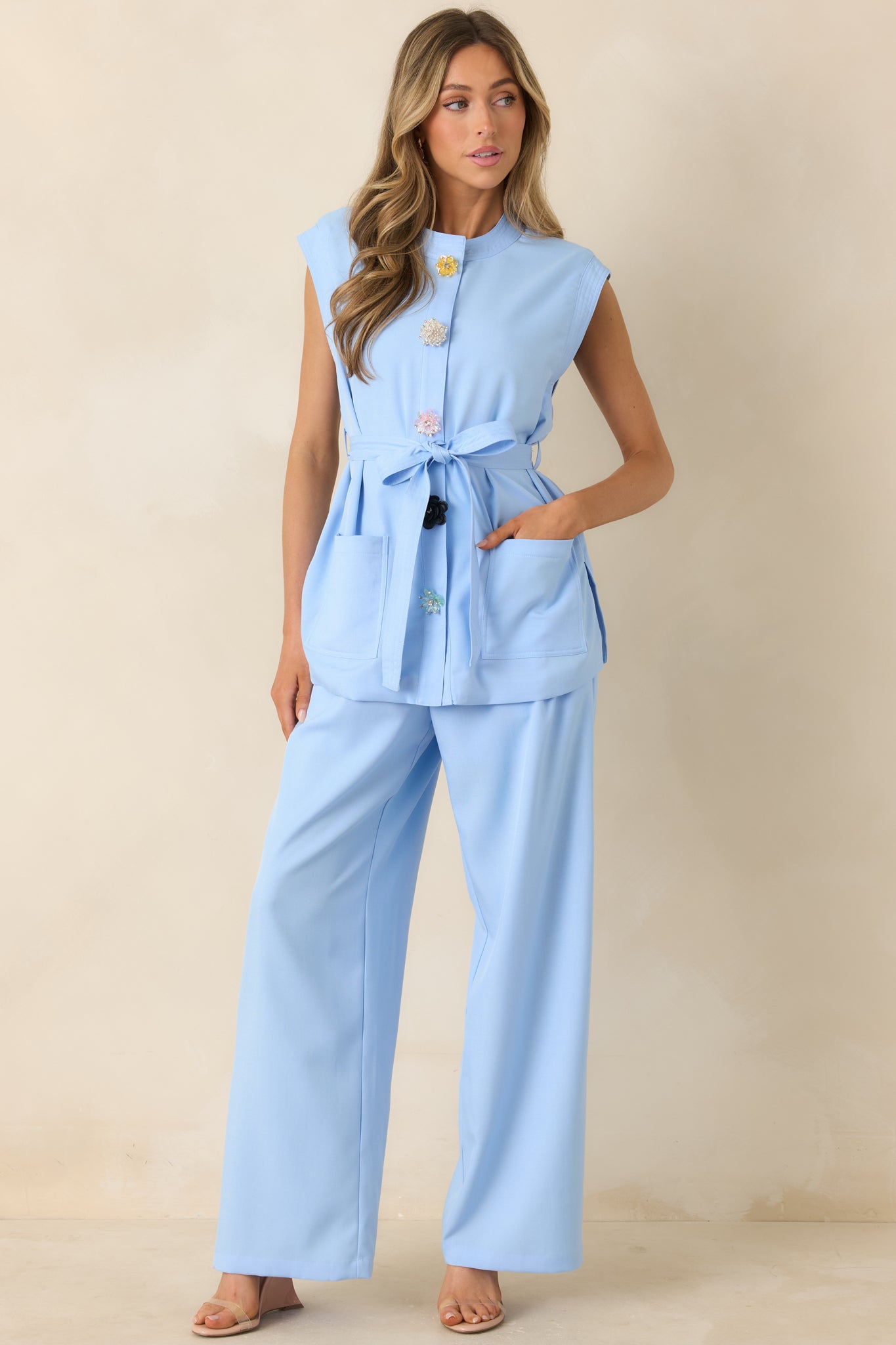 Light blue top with clean silhouette, decorative buttons, and subtle shaping