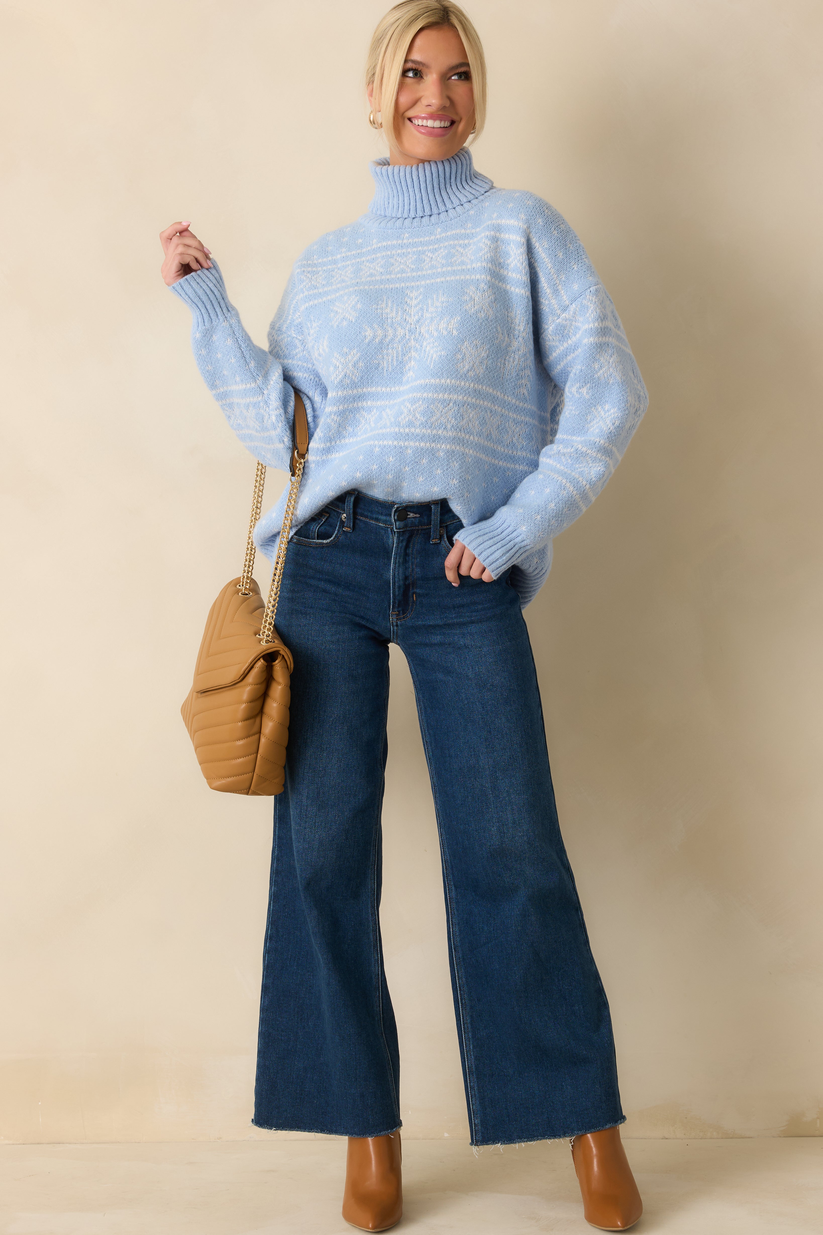Light blue turtleneck sweater with ribbed trim and a classic snowflake motif for a seasonal style.