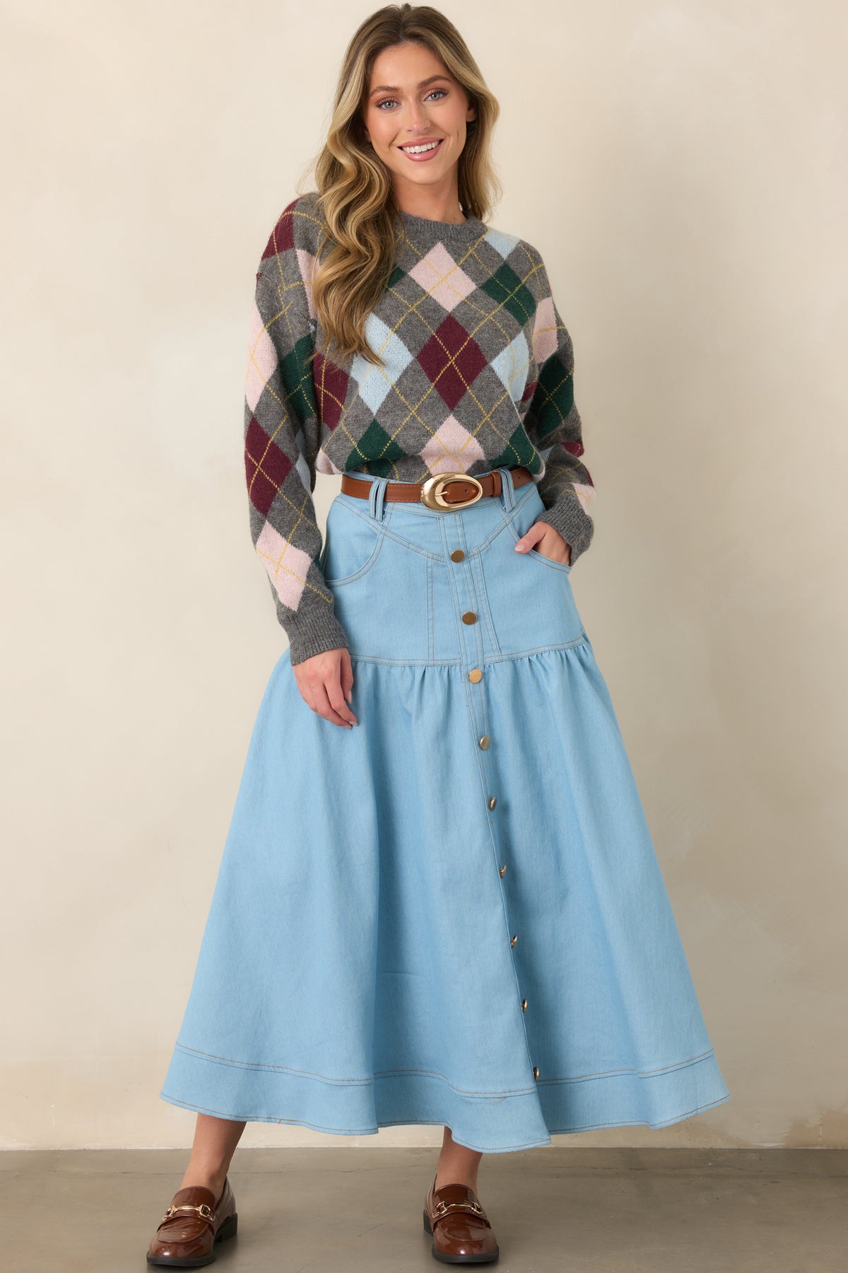 Light wash maxi skirt in structured denim with a tailored waistband, gold-tone buttons, softly flared tiers, and polished wide hem.