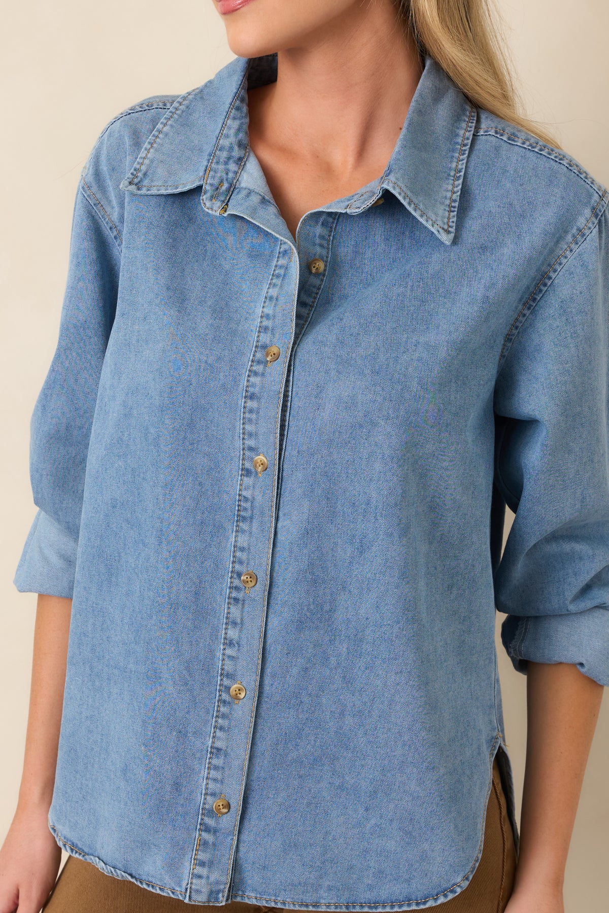 Close-up of the light wash cotton denim highlighting the collar, front buttons, and stitching details.