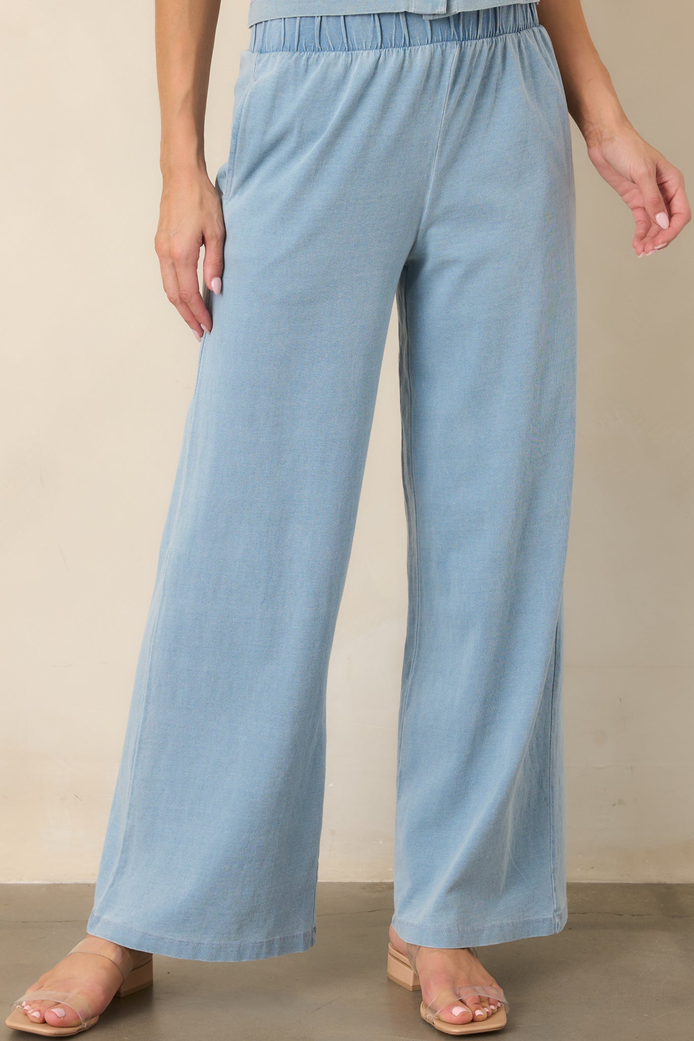 Light denim blue lounge pants highlighting the high-rise elastic waistband and softly draping wide-leg silhouette.